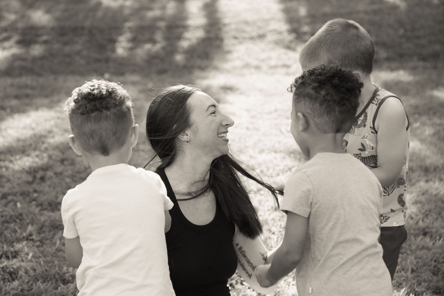 Natural outdoor family photography sequence showing casual interactions in black and white.