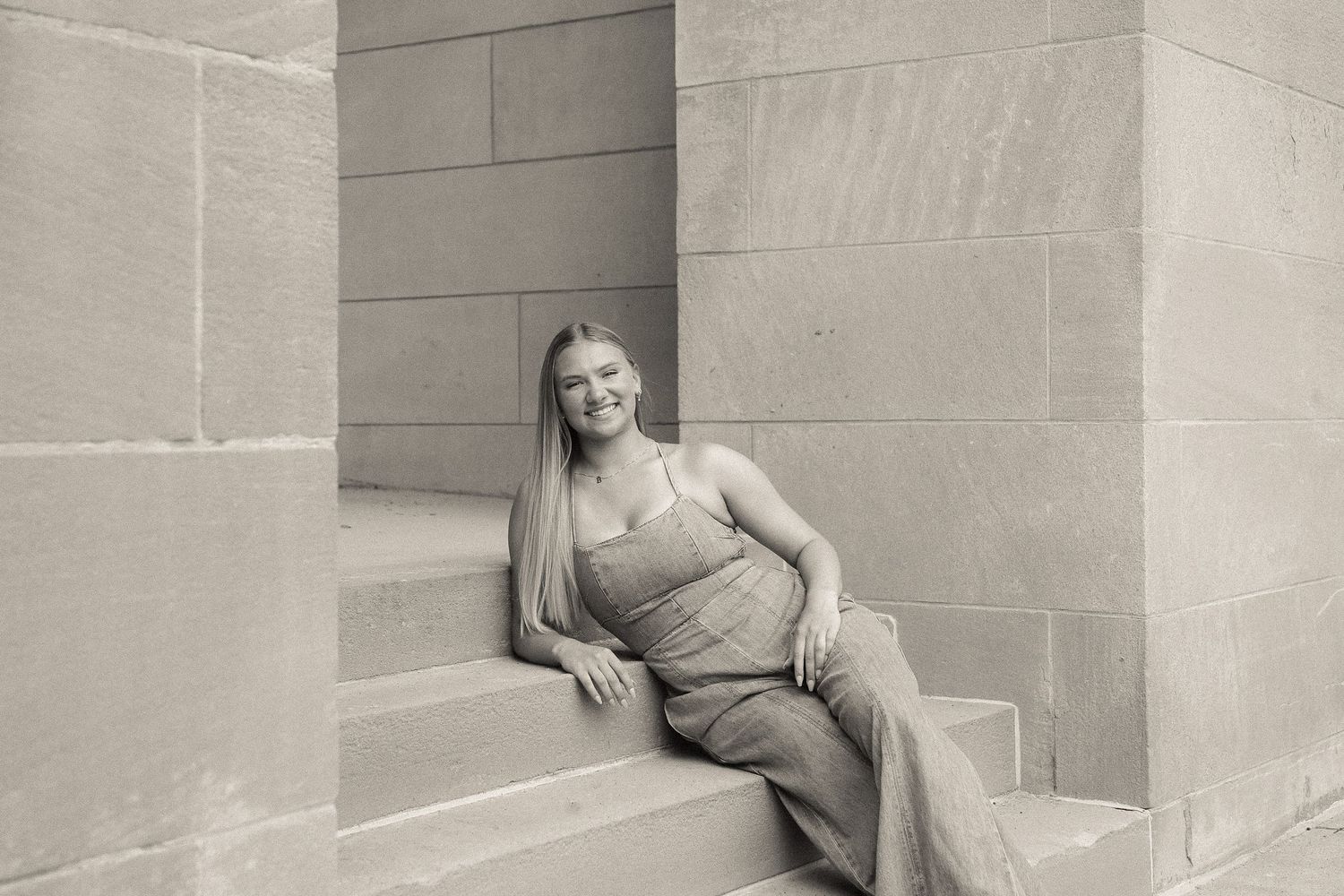 A casual portrait session against a neutral stone wall background.