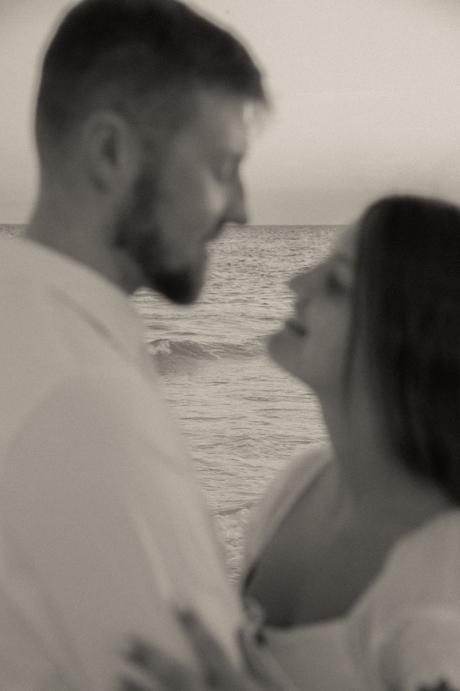 Intimate black and white portrait of couple by the ocean.