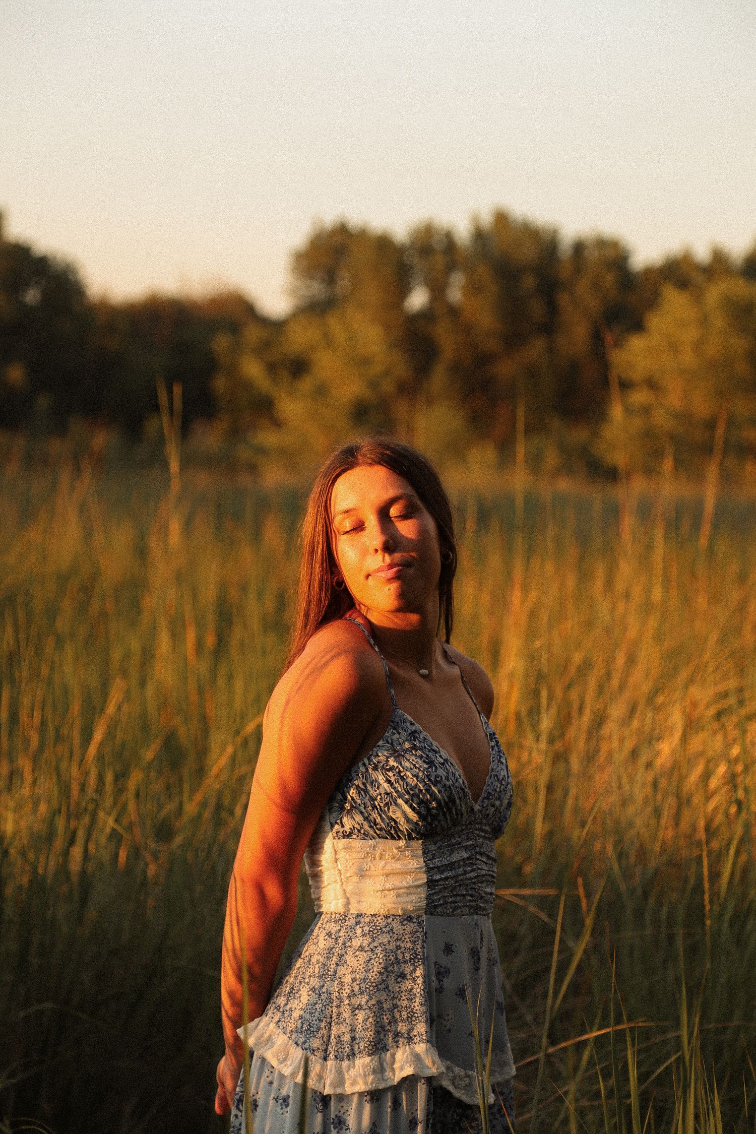 Warm sunset light illuminates a summer photoshoot among tall grass and wildflowers.