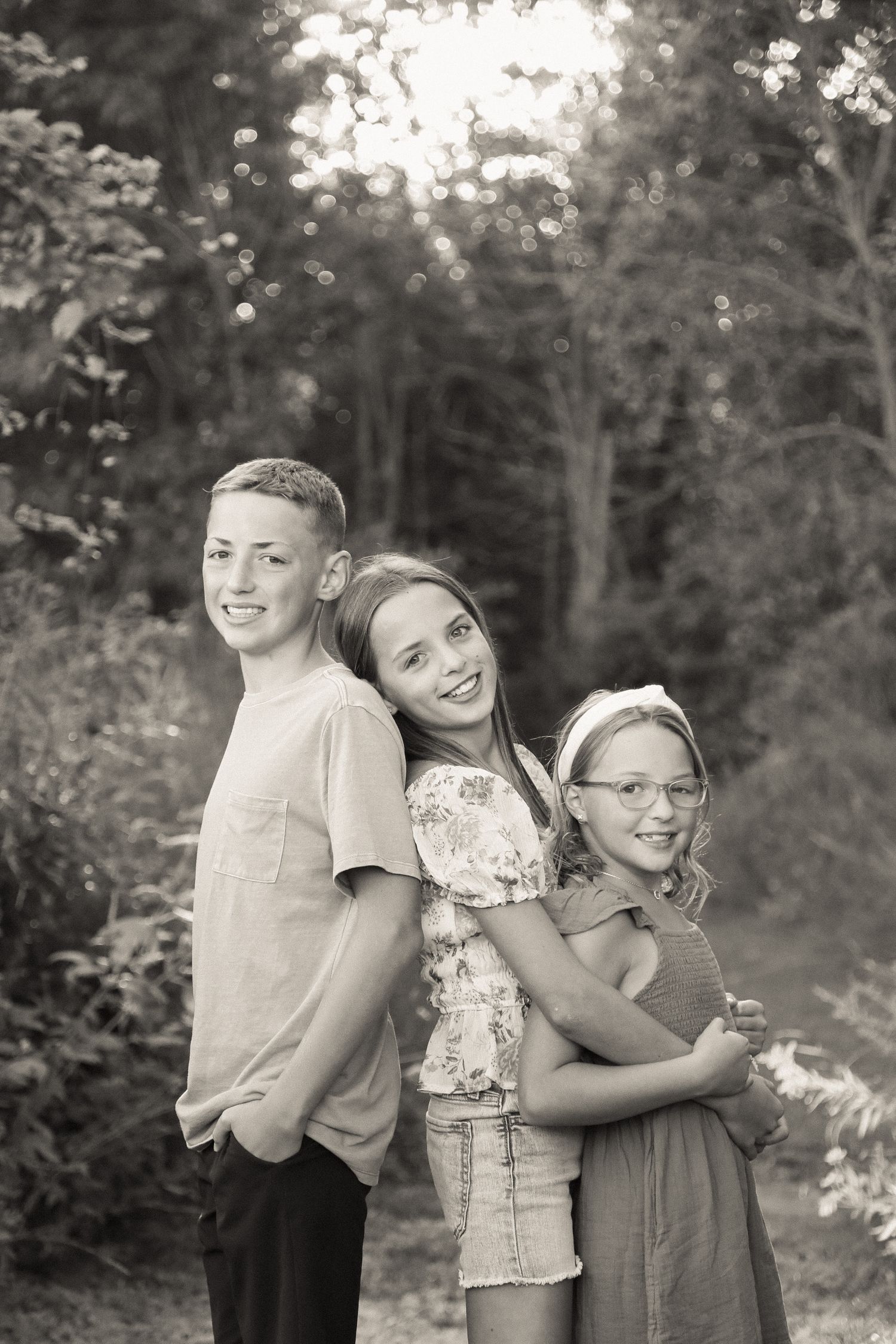 Siblings share a tender embrace while posing for outdoor portraits.
