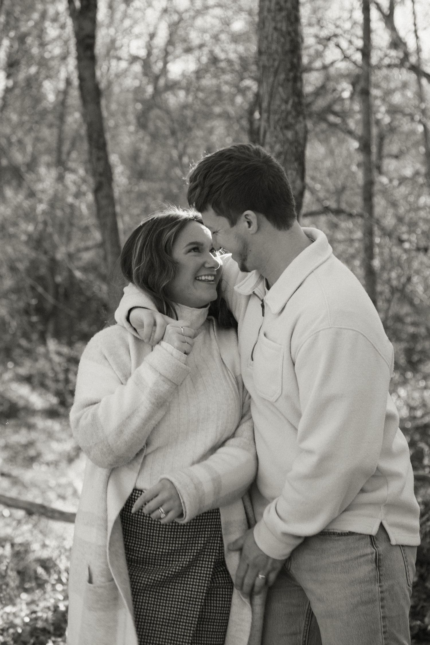 A series of tender moments between a couple in white sweaters during an autumn forest photoshoot.
