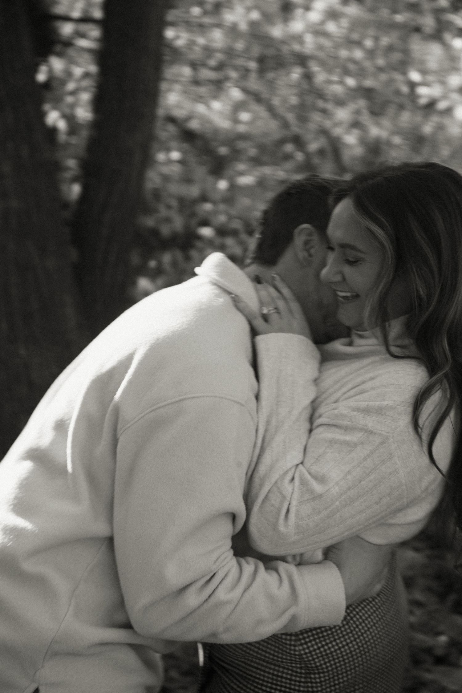 A romantic black and white series showing a couple embracing in a sunlit forest.