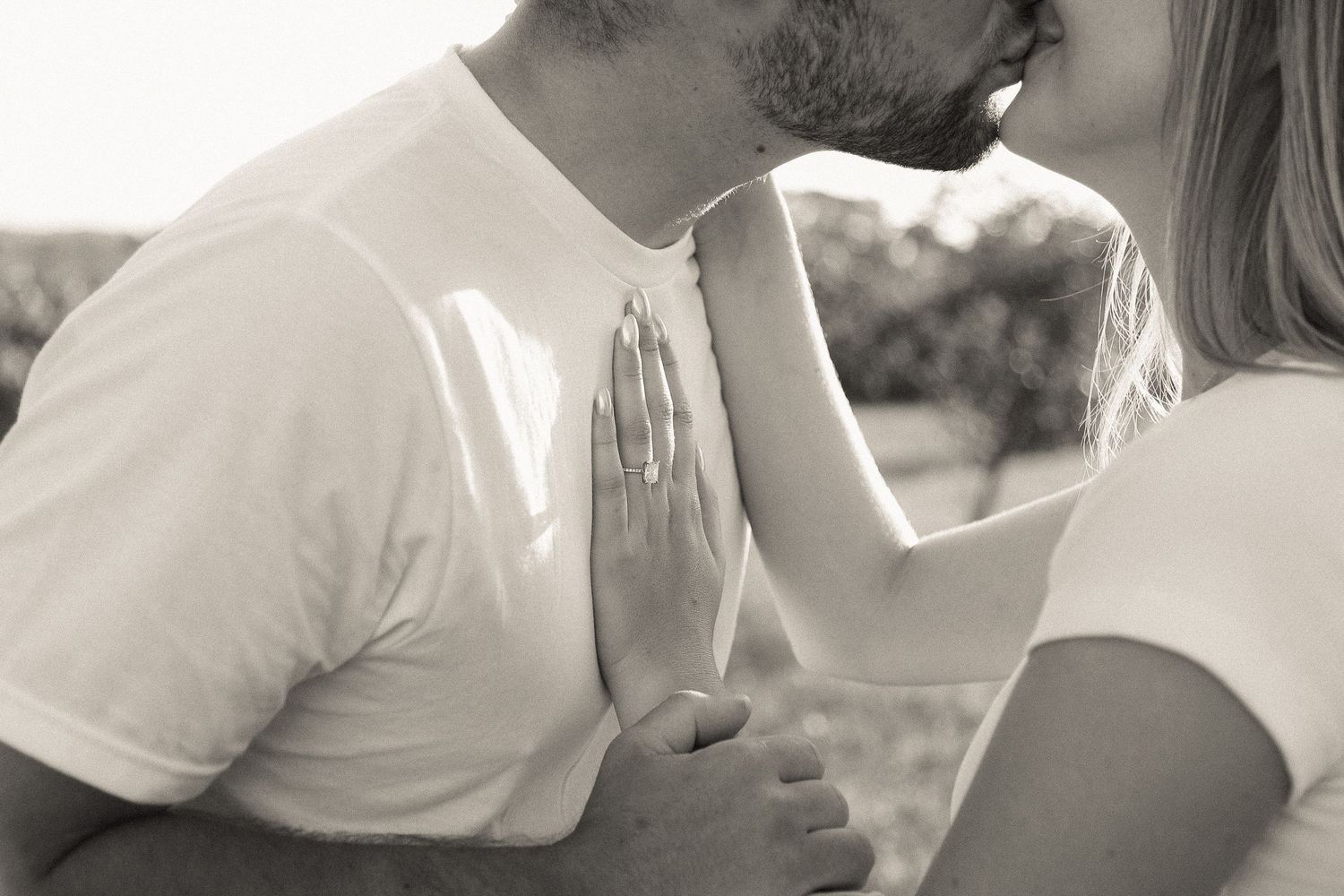 Intimate close-up of couple embracing in soft natural lighting.
