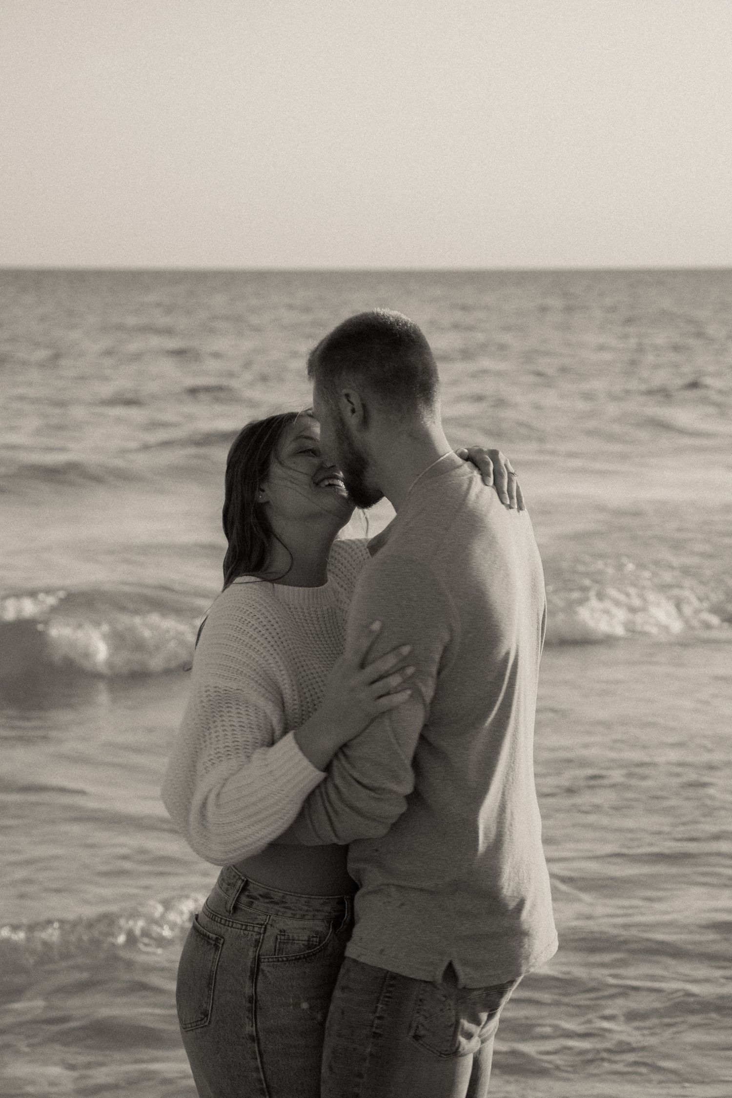 Romantic couple sharing an intimate moment on the beach at sunset.