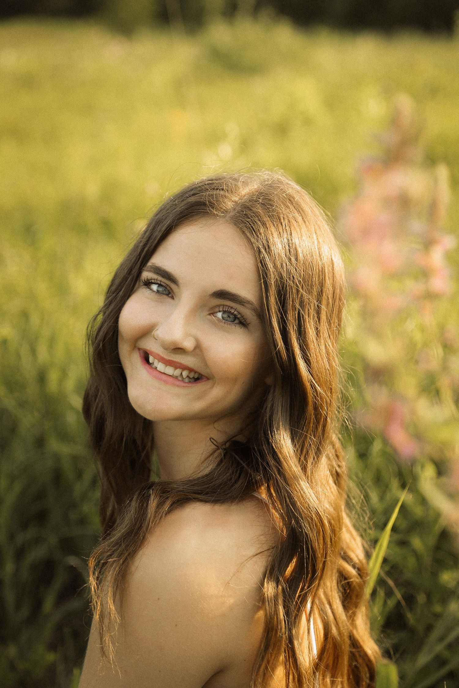 Golden hour lighting creates a warm glow in this outdoor portrait among wildflowers.