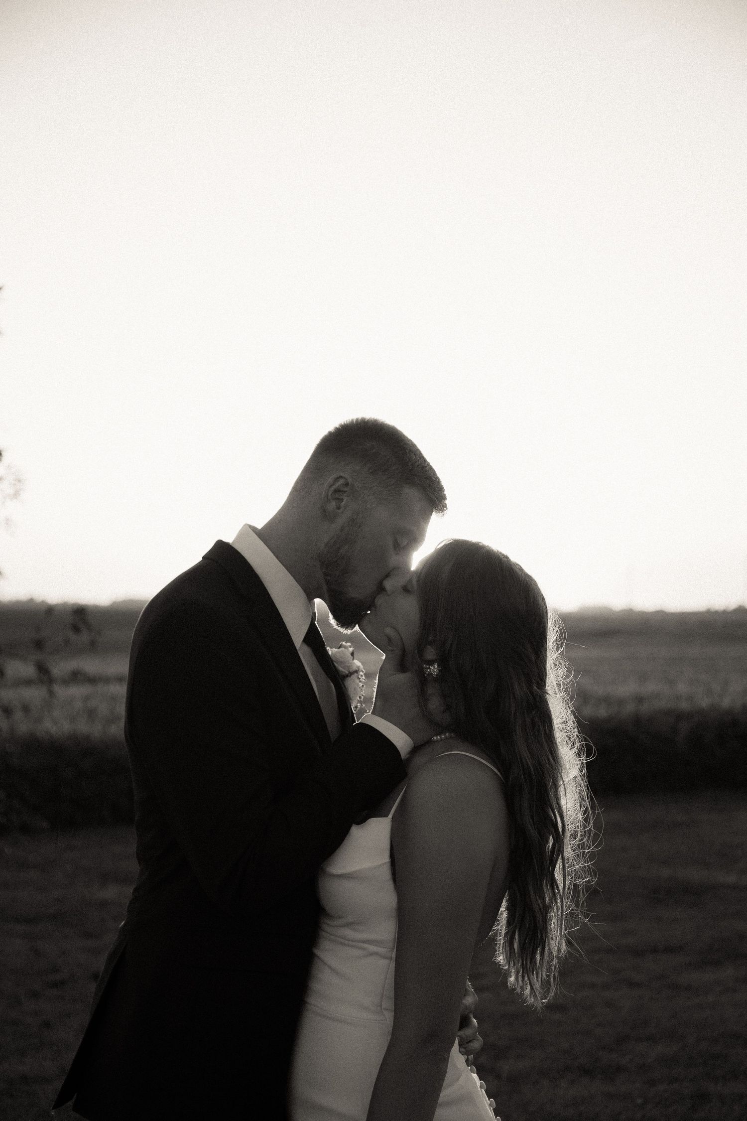 Black and white portrait of couple sharing an intimate moment at sunset.