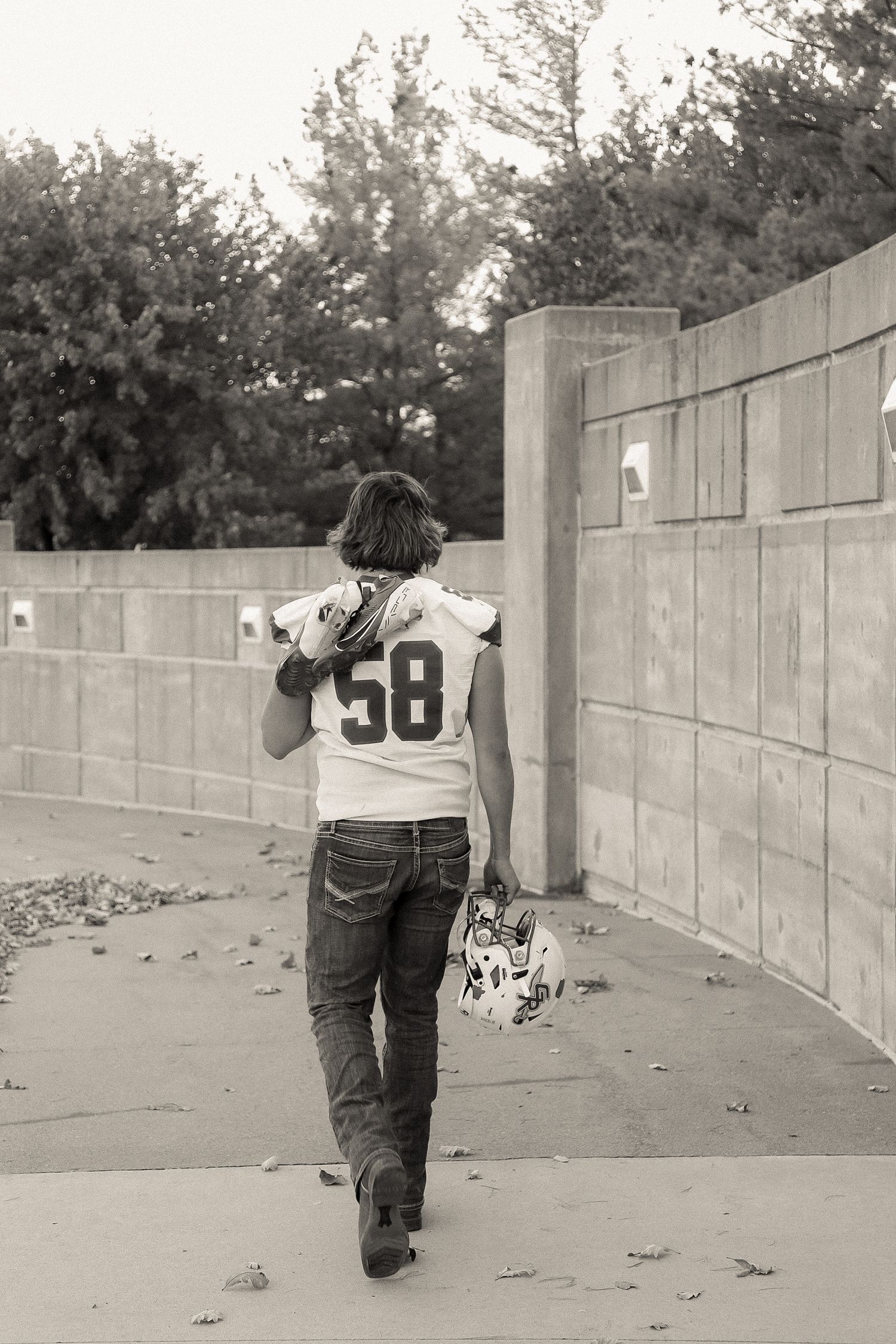 Series of poses showing someone walking along a curved concrete wall outdoors.
