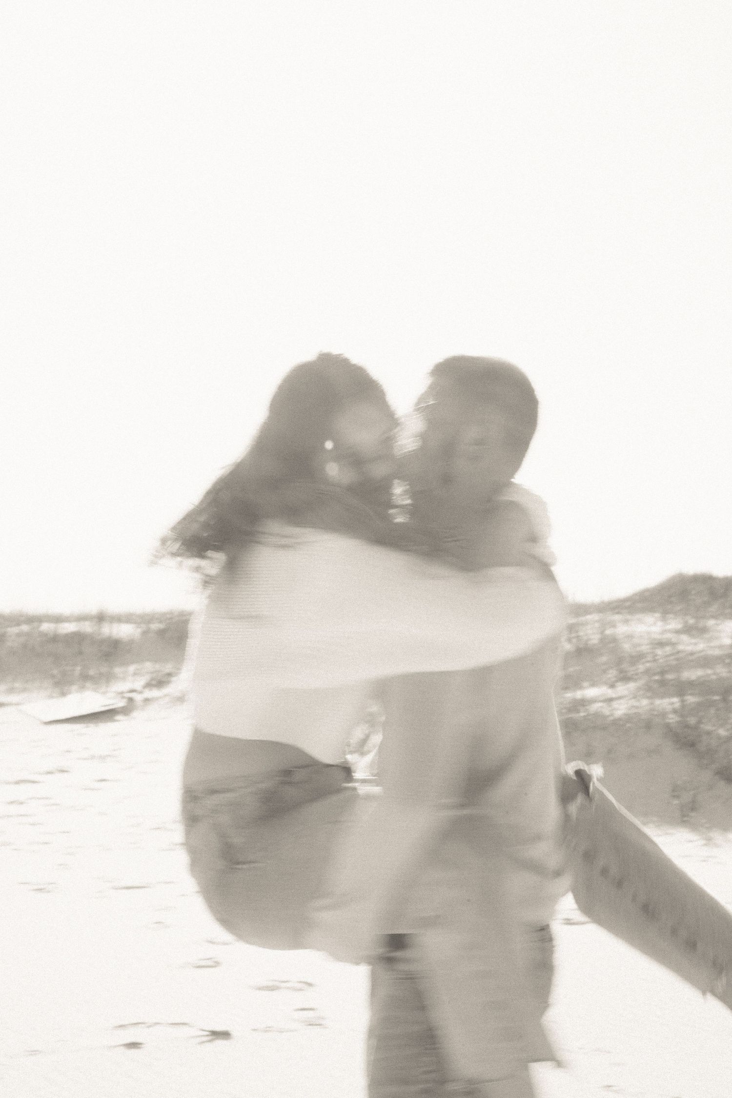 Dreamy black and white beach portraits with soft focus and motion blur.