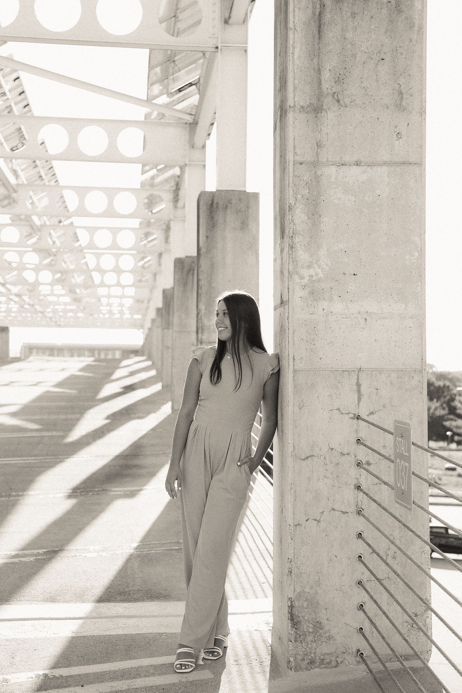 High contrast black and white portraits showcasing movement and poses between concrete columns.