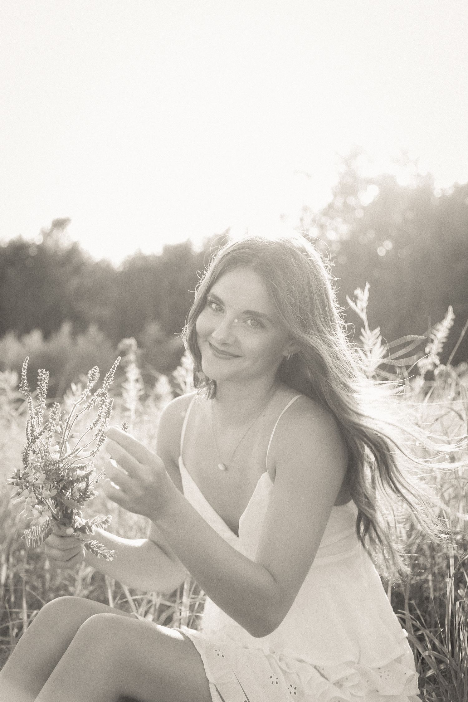 Soft backlight creates a dreamy atmosphere in this outdoor summer portrait with wildflowers.