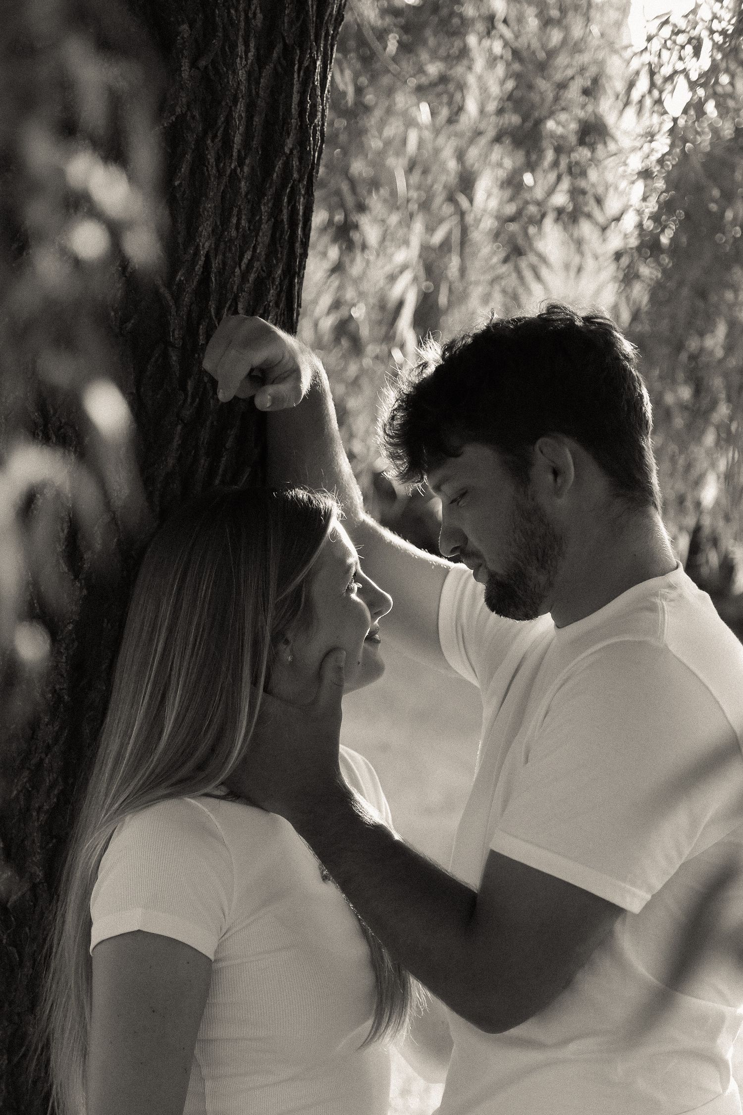 Intimate black and white portrait sequence under a tree.