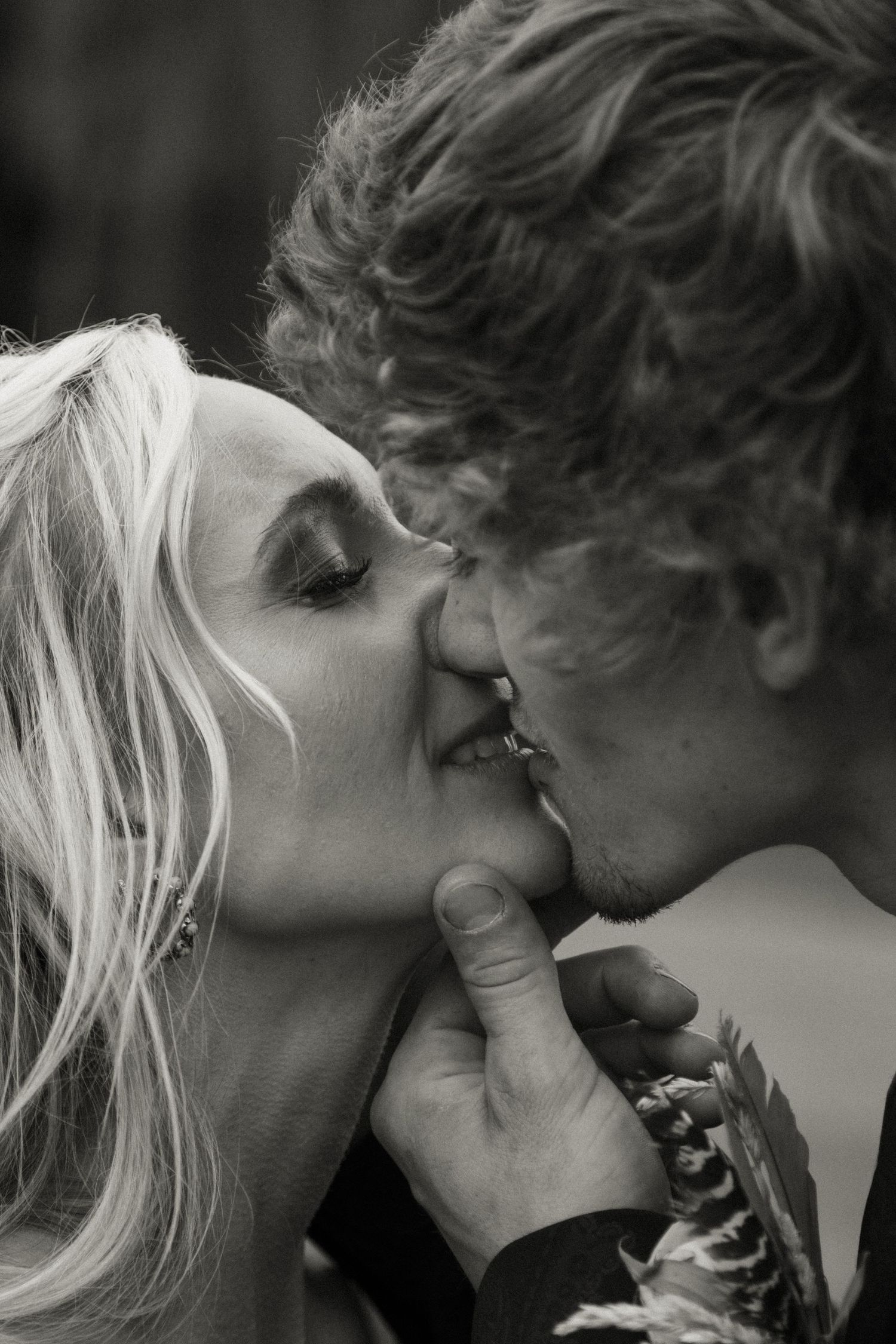 Black and white close-up of bride and groom sharing a romantic kiss on their wedding day.