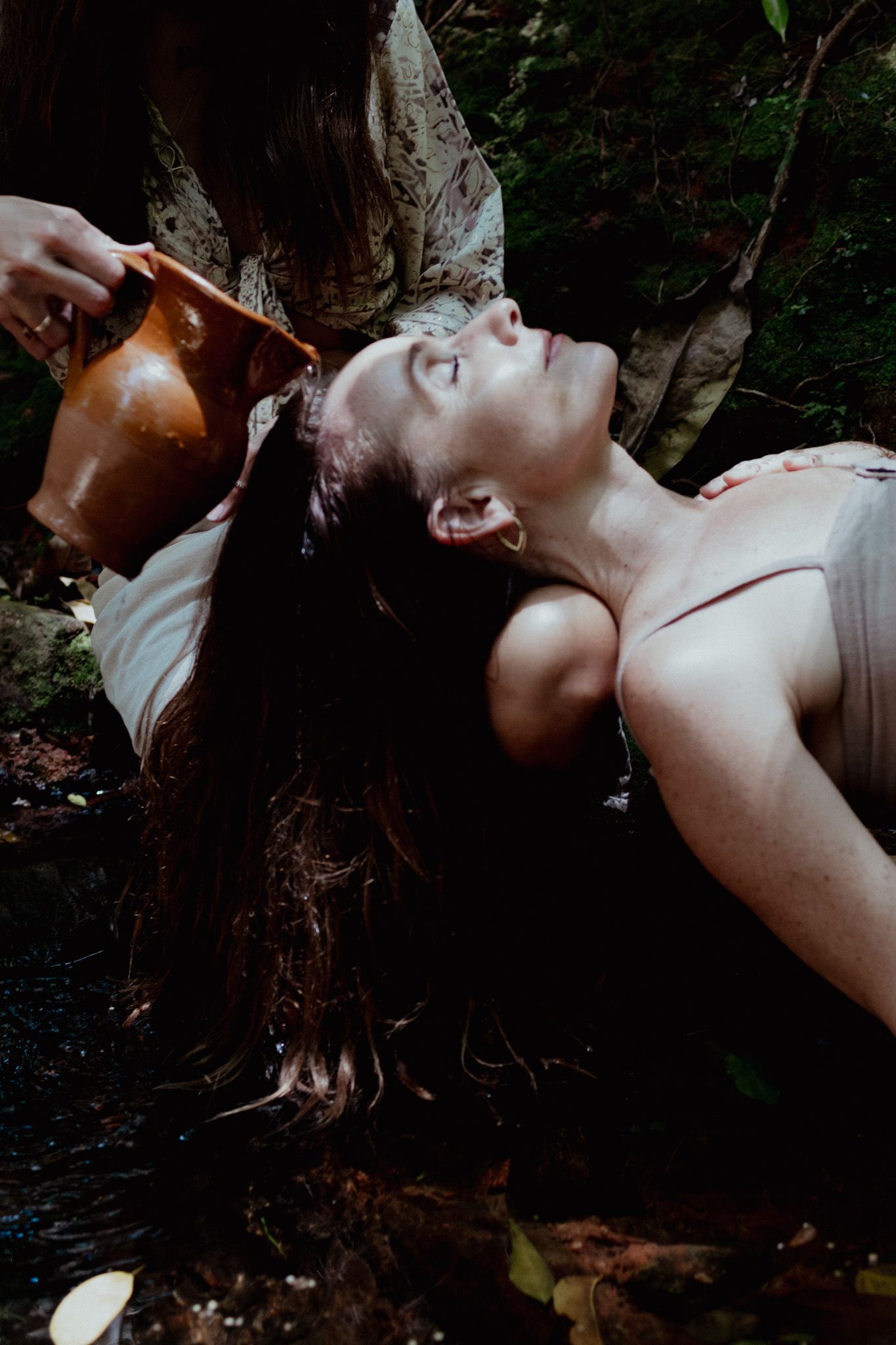 Artistic portrait showing dramatic lighting and shadows in a natural setting.