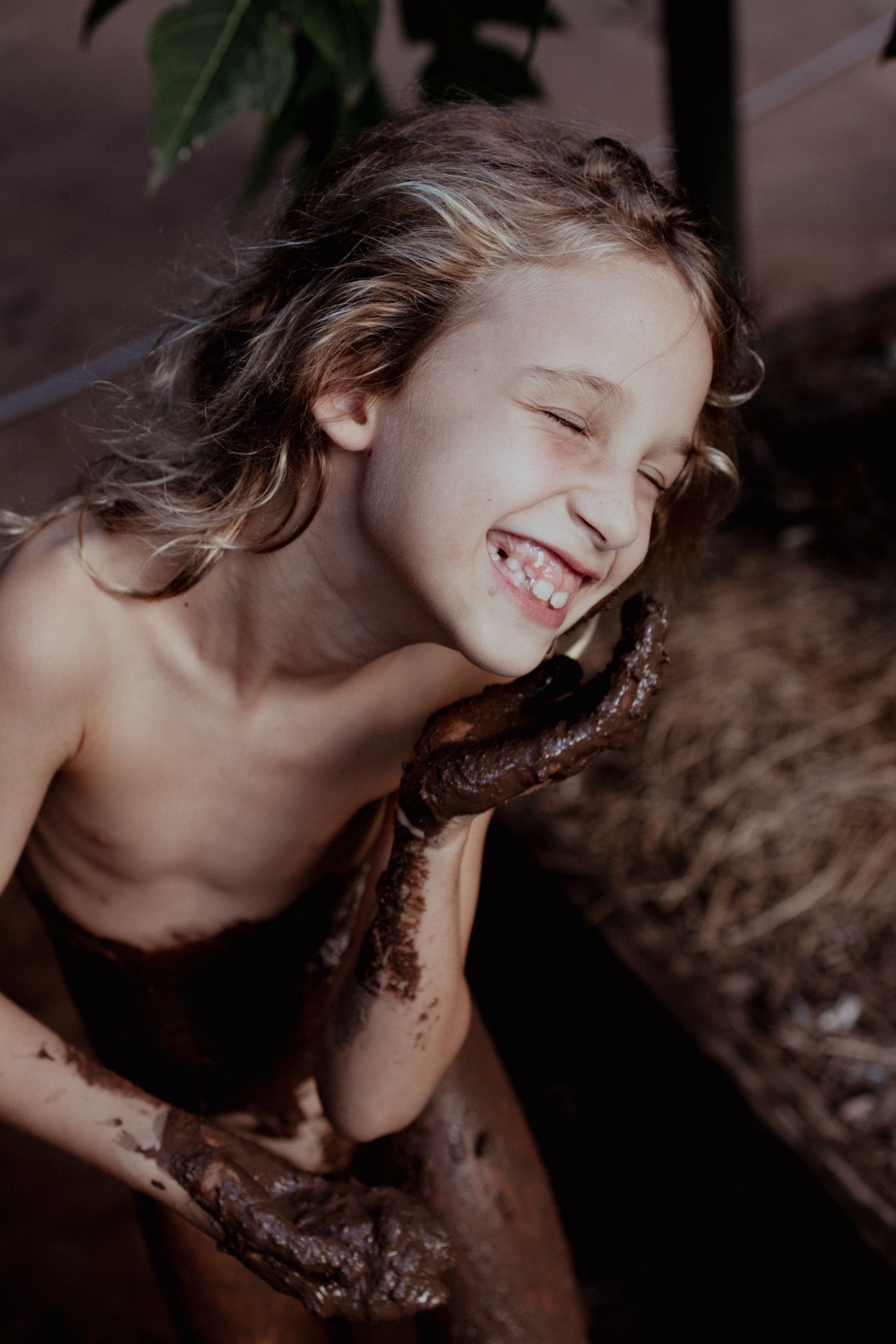 Joyful expression captured during mud spa treatment.