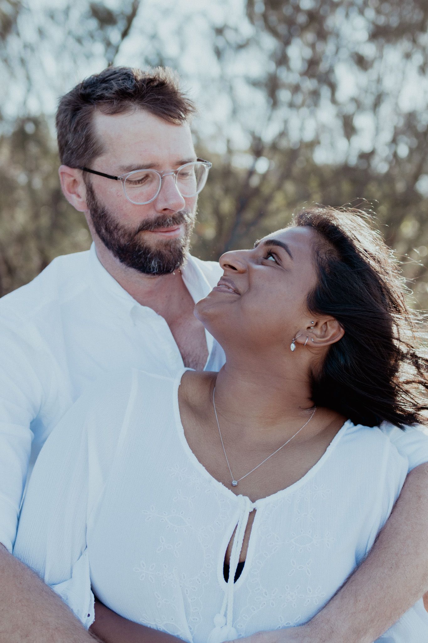 An intimate outdoor portrait session showing loving couple moments in white attire.
