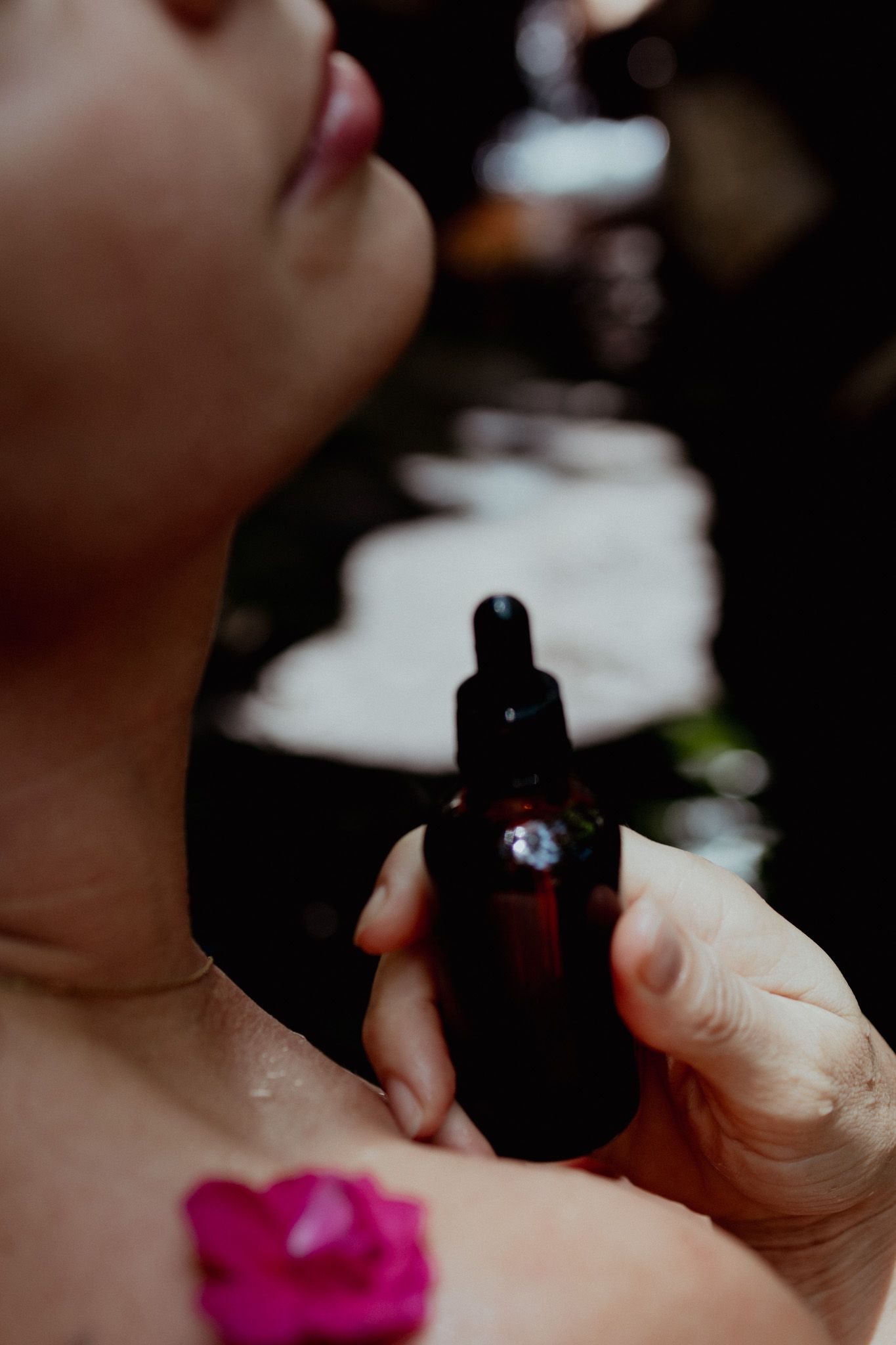 Detailed shots of hands holding a dark bottle against a shadowy background.