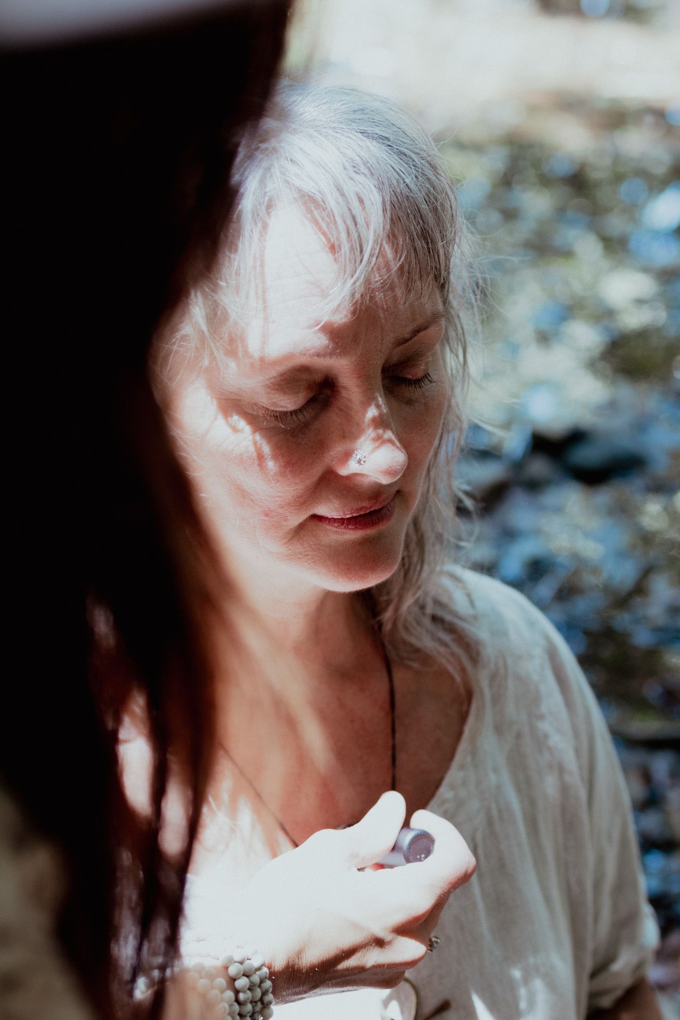 A soft, intimate close-up portrait in natural lighting among trees.