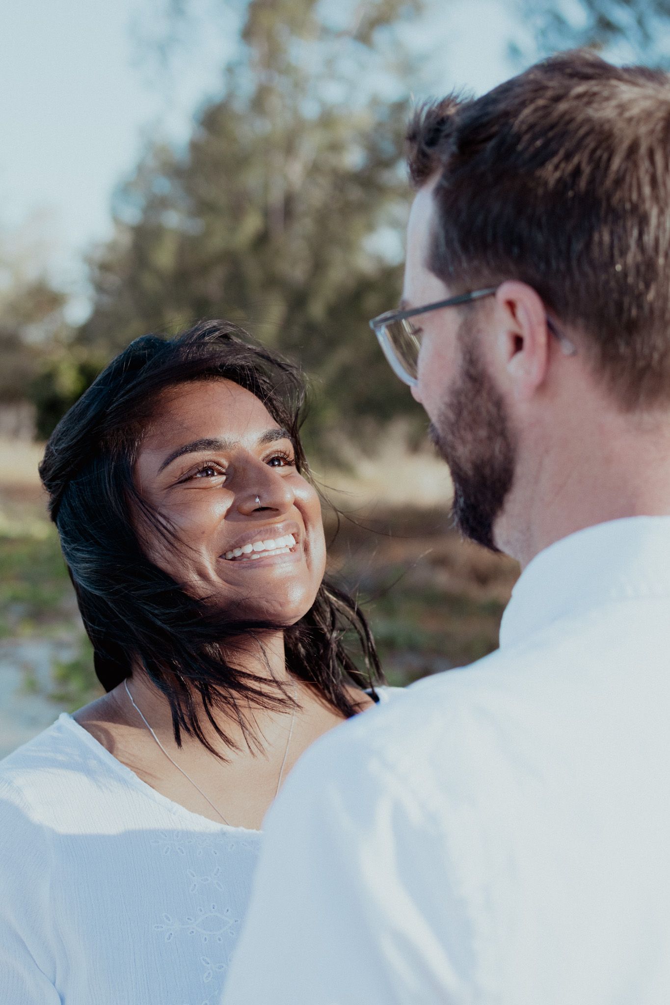 A joyful outdoor photoshoot capturing candid laughter and connection between a couple.