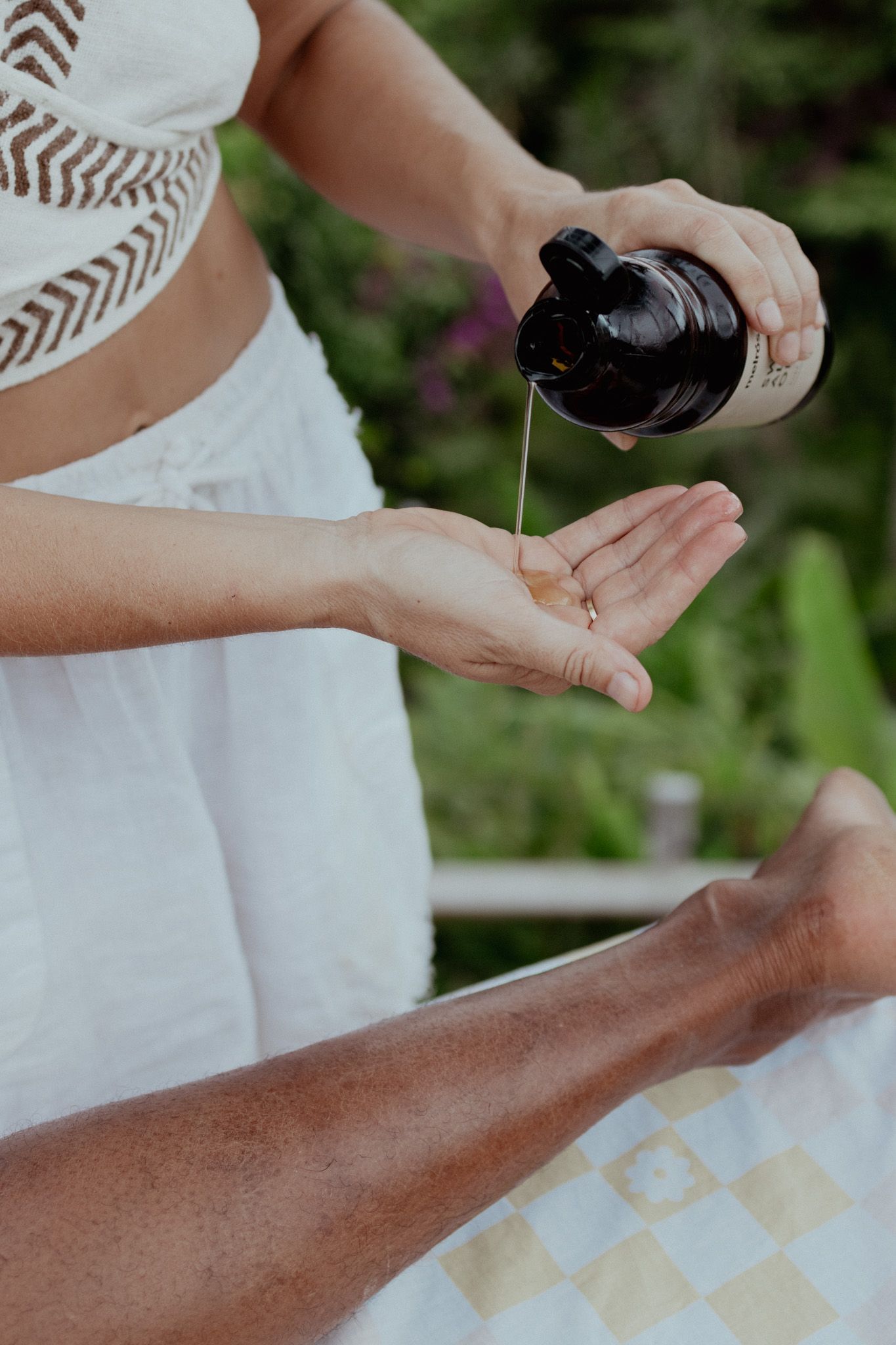 Close up of hands applying massage techniques during outdoor treatment session.