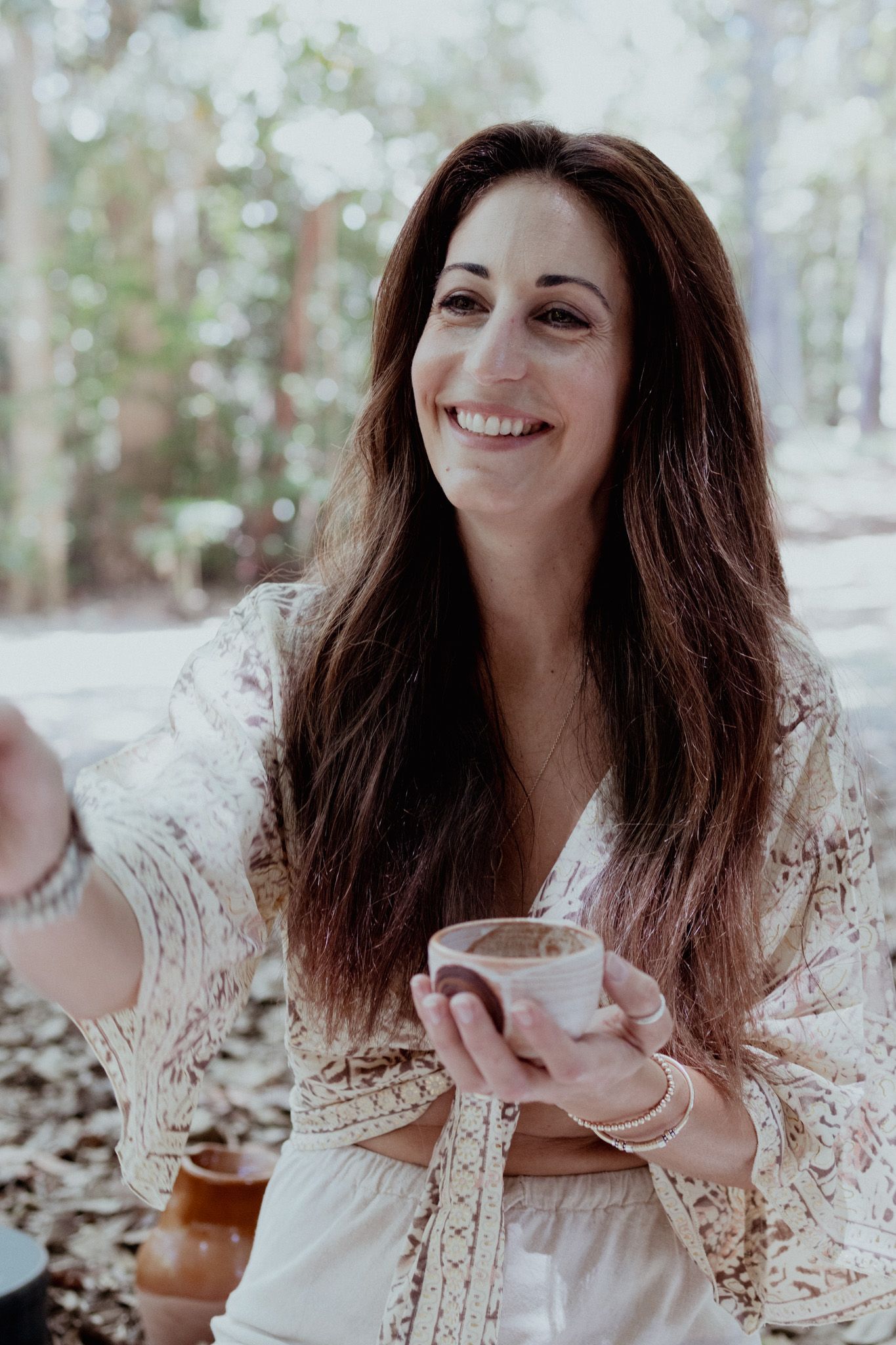 Natural light portrait capturing joyful tea drinking moment in outdoor setting.