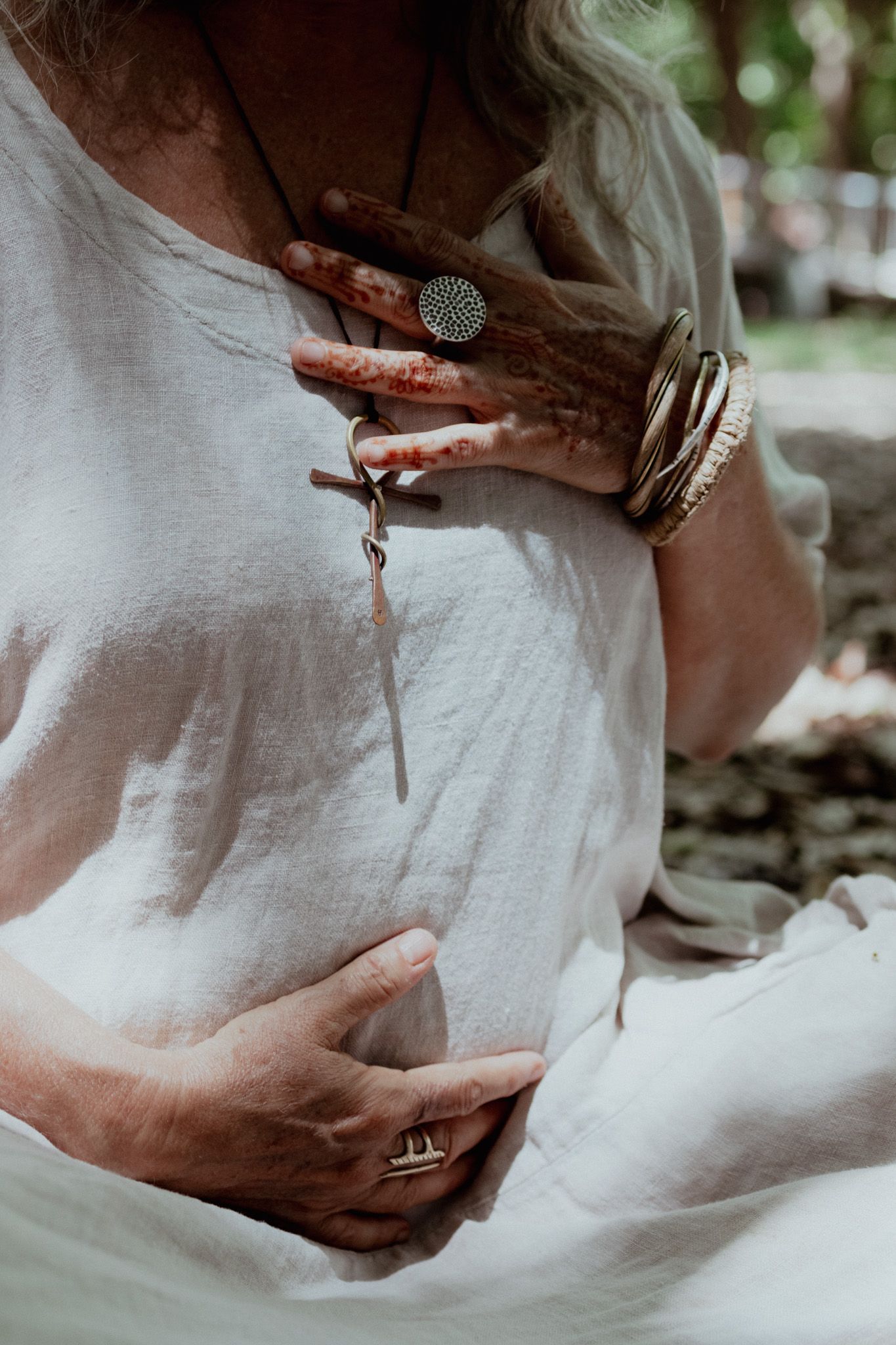 Close-up shots of hands delicately working with white fabric and jewelry.