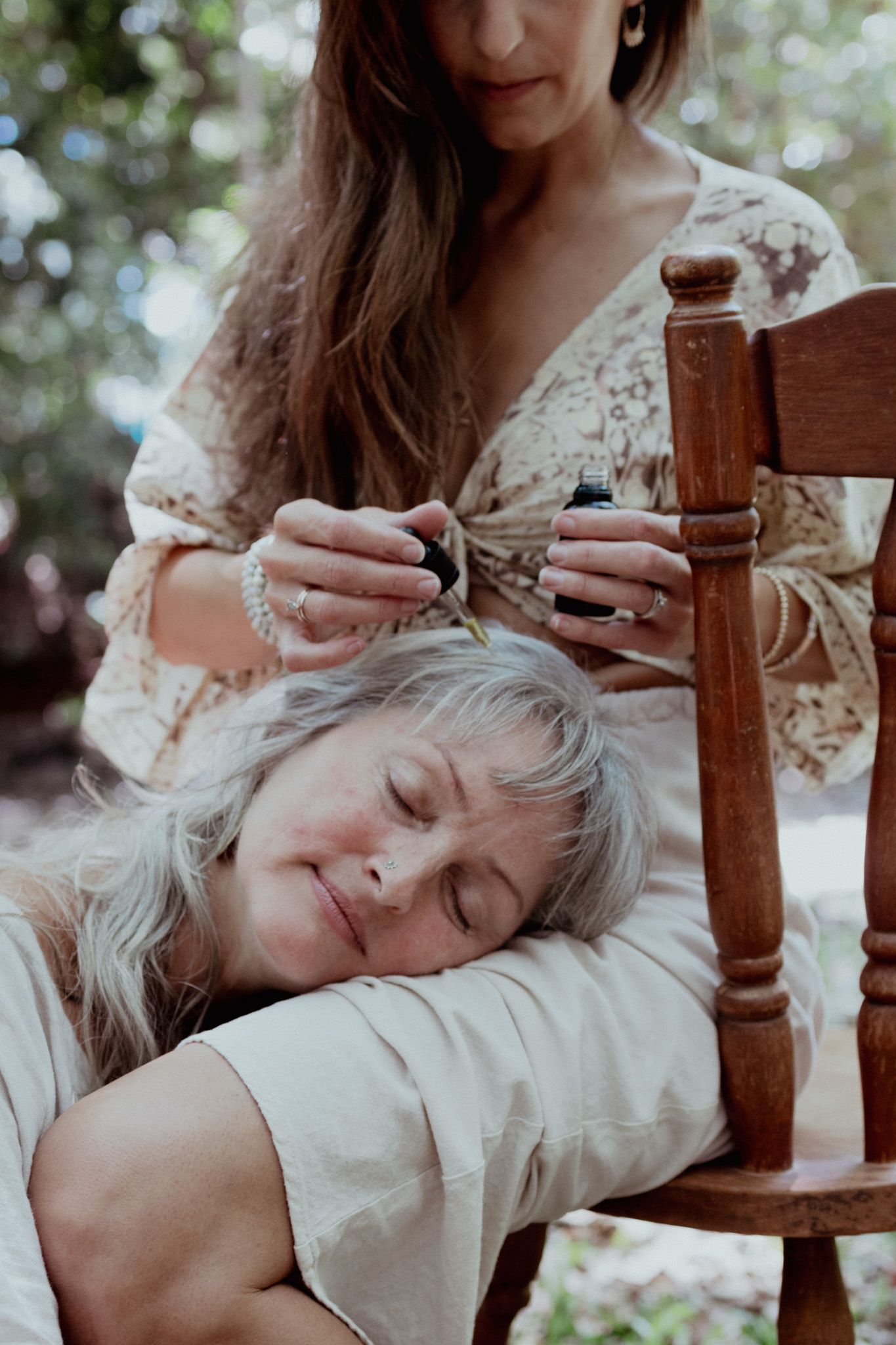 Artistic portrait of two people sharing a quiet moment in a rustic wooden chair.