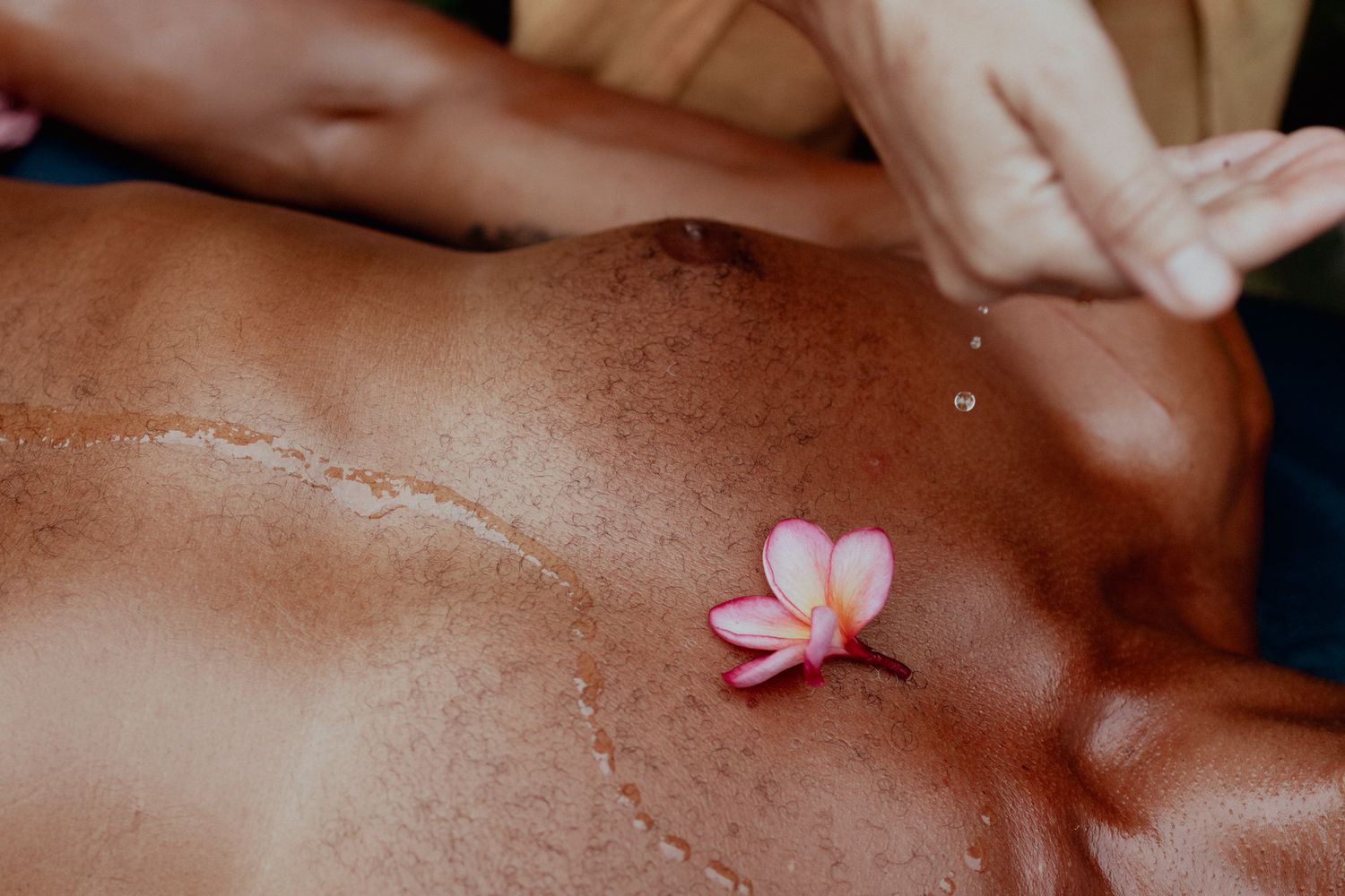 Close-up of hands performing therapeutic massage techniques on client's back.