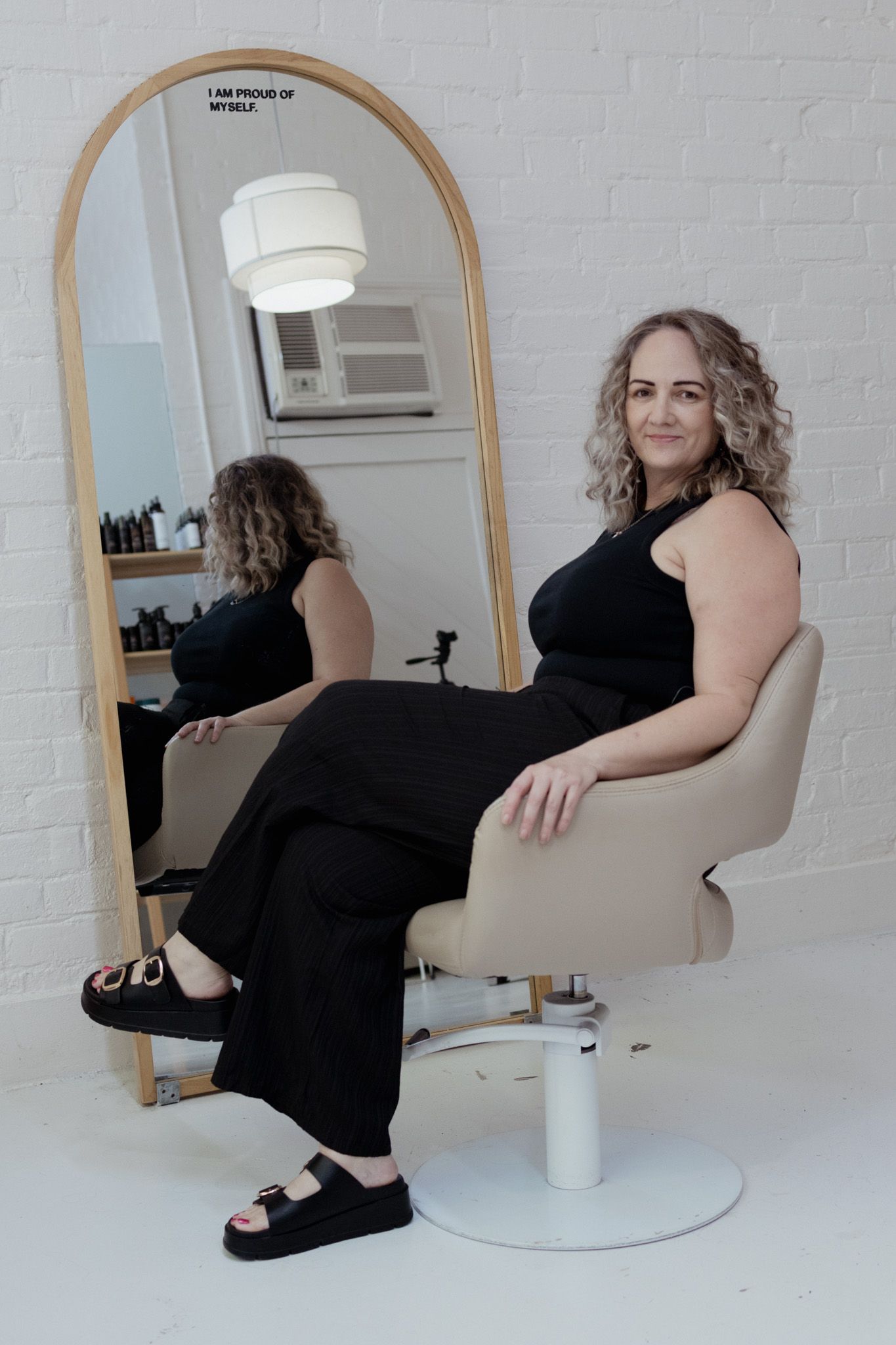 Artistic sequence of poses in a minimalist white studio with arched mirror.