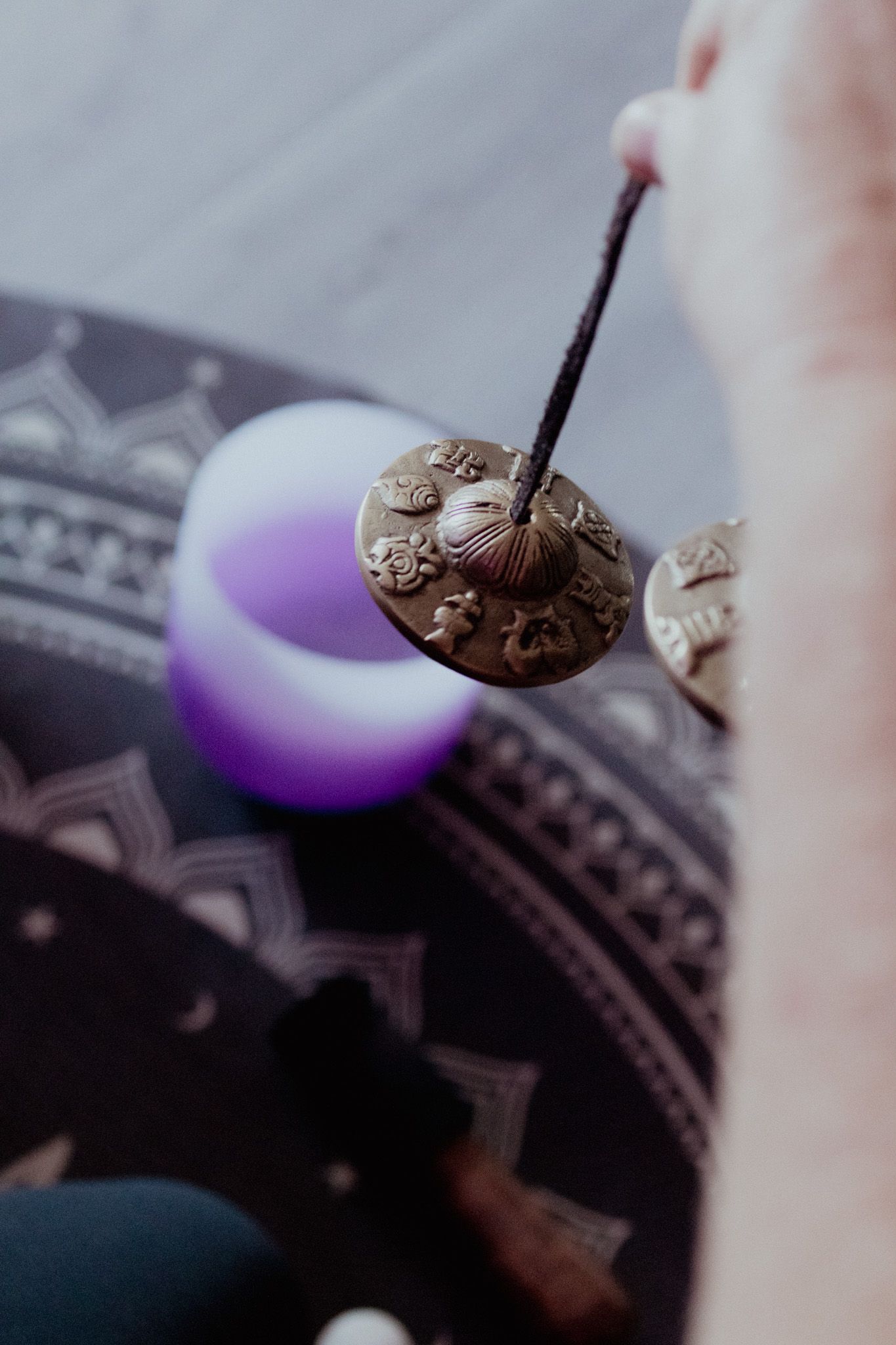 Close-up of a mallet striking a crystal singing bowl creating vibrations.