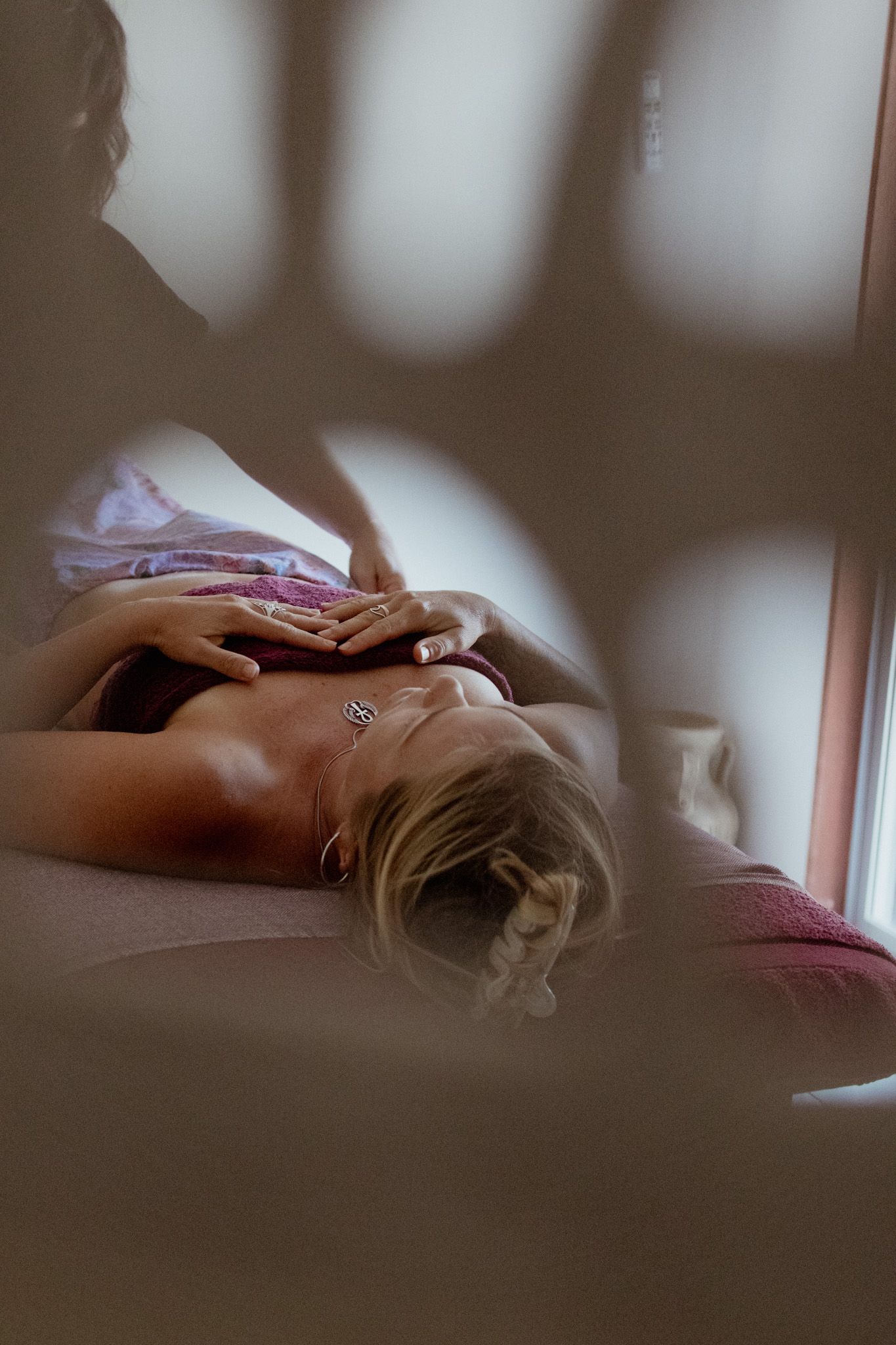 Atmospheric side view of relaxation therapy session near window with natural light.