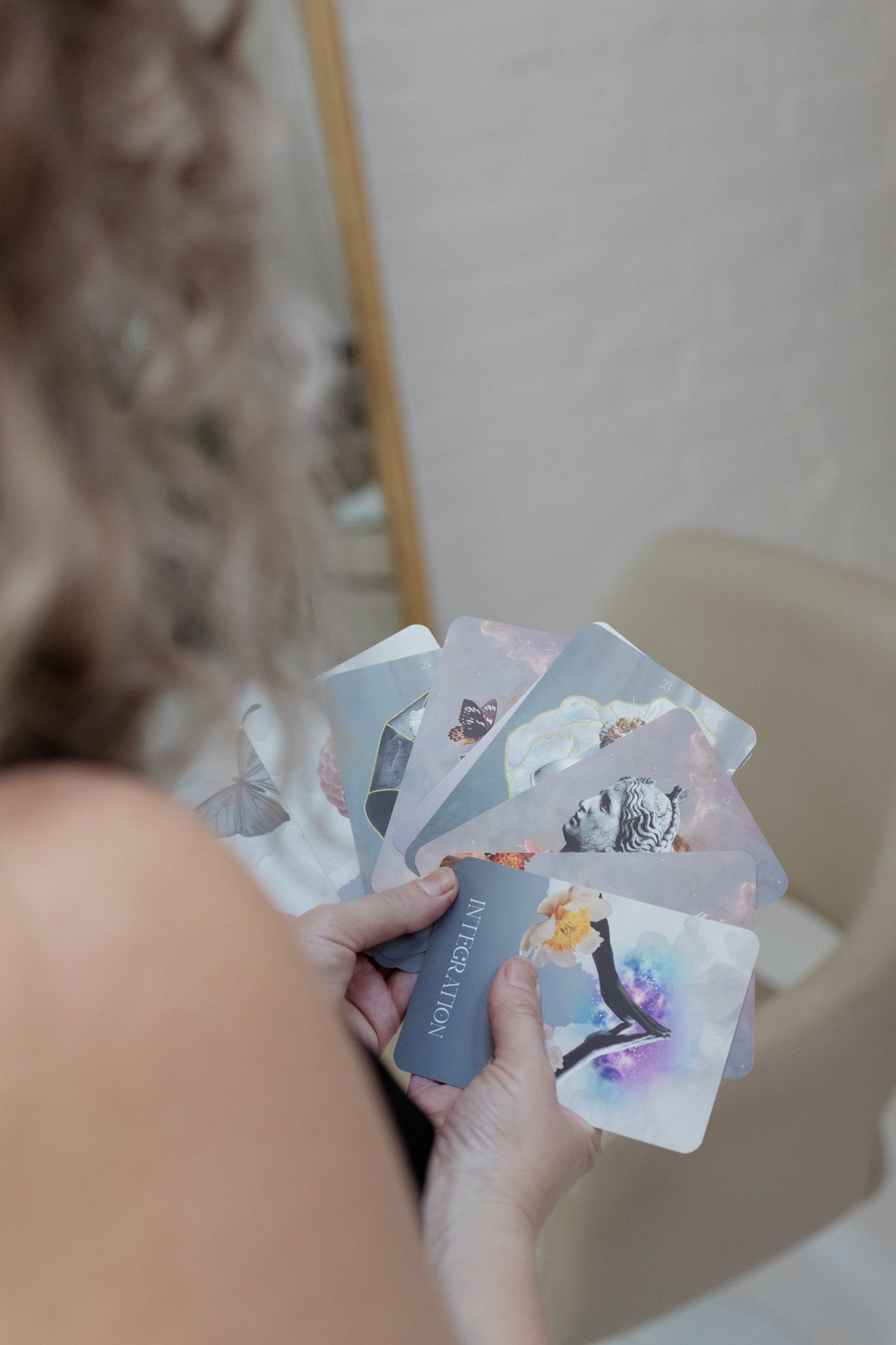 Hands holding and displaying holographic cards in a fanned arrangement.