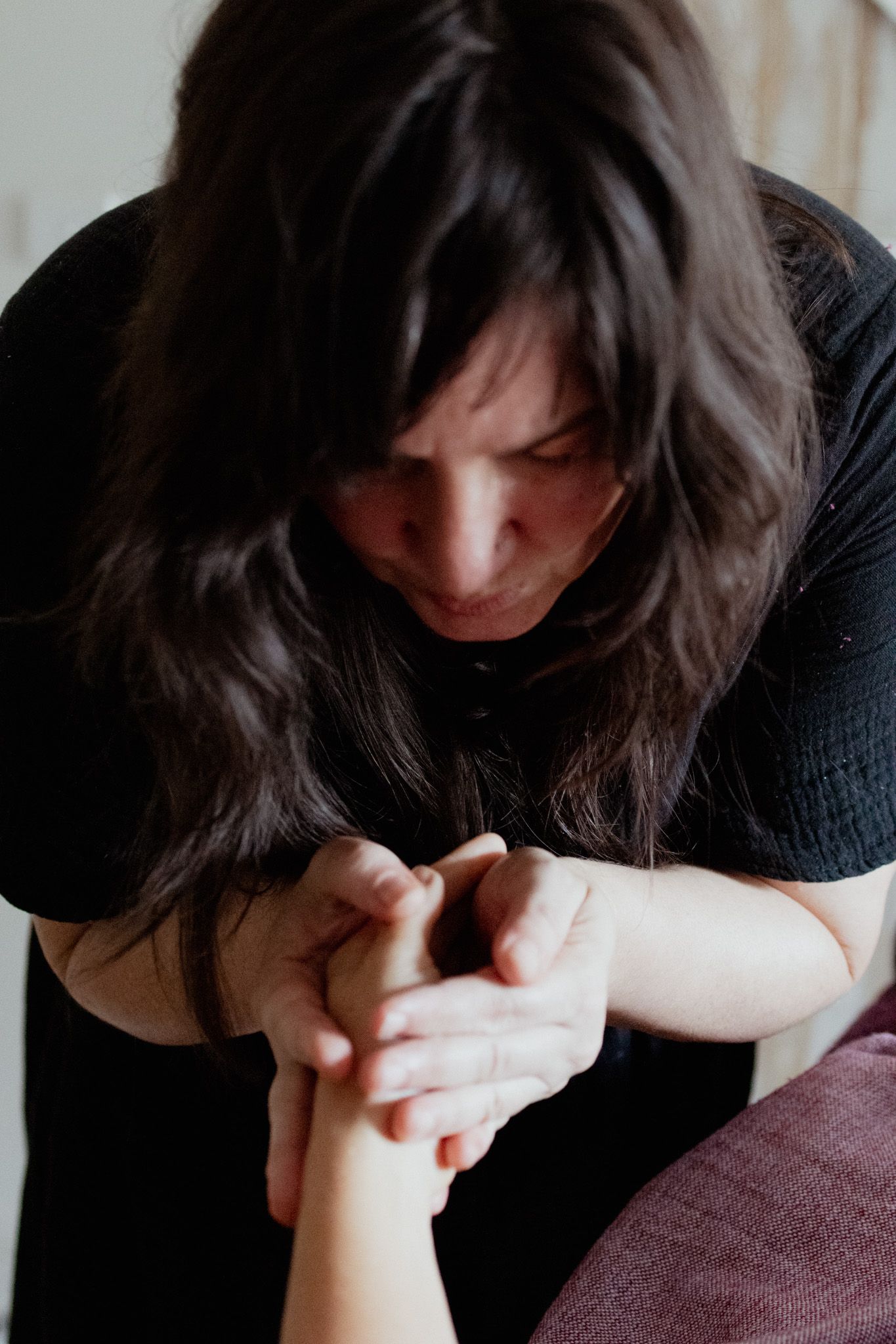 Therapist performing detailed massage work with focused concentration.