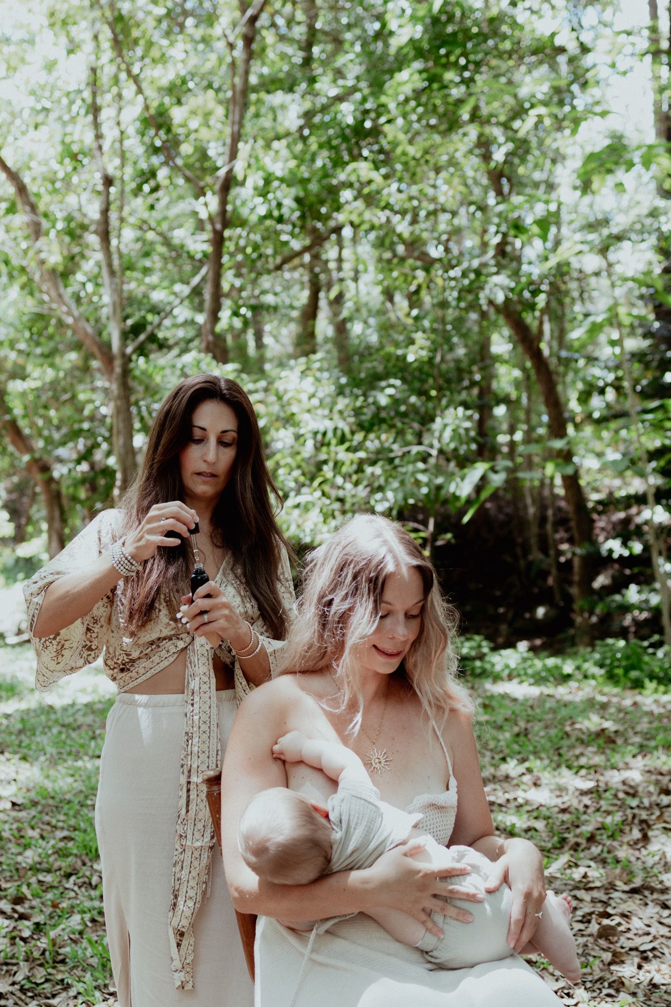 Two people share an intimate moment in nature while caring for a baby.