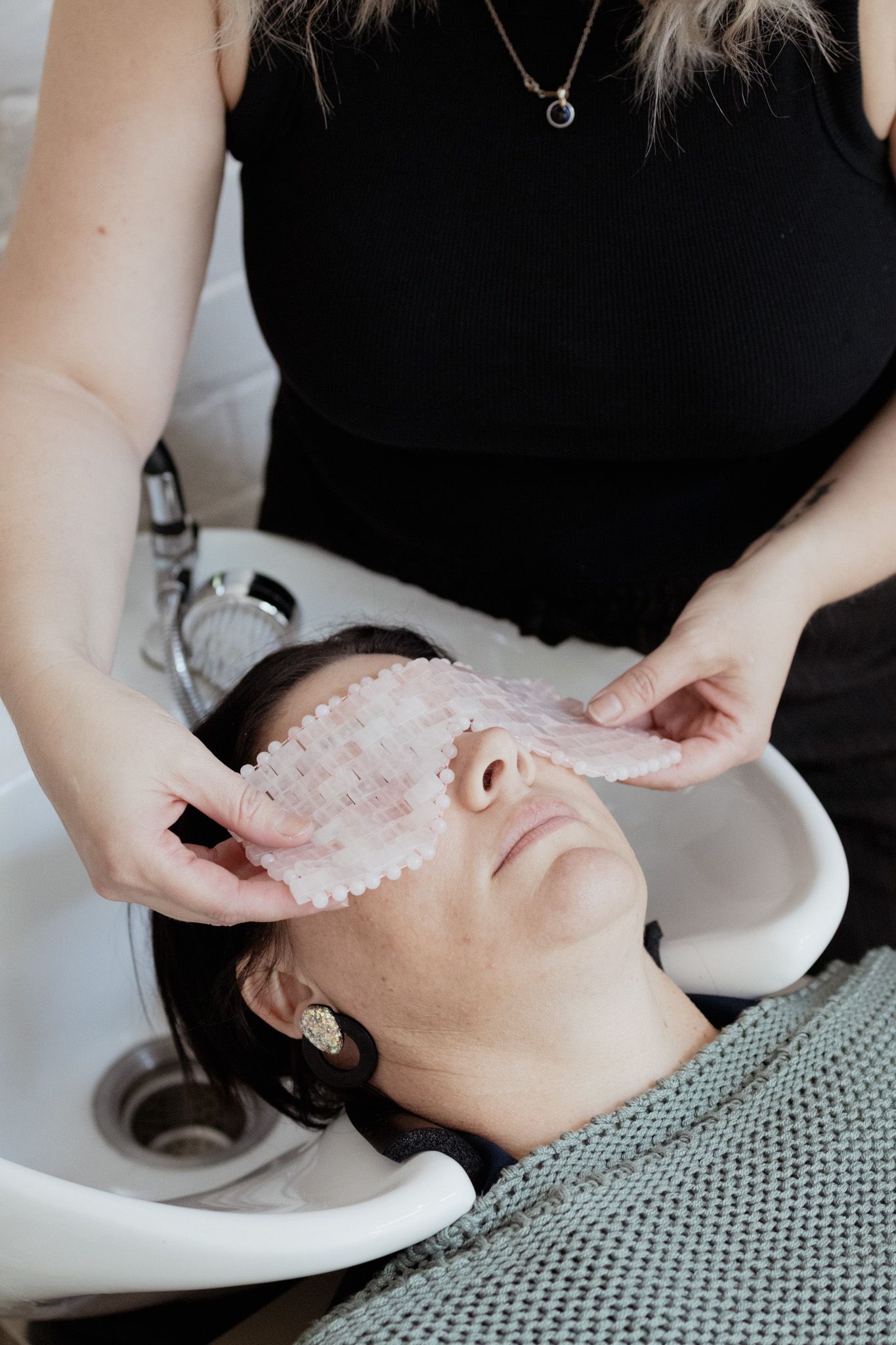 Facial treatment sequence showing application of a white mask in a spa setting.