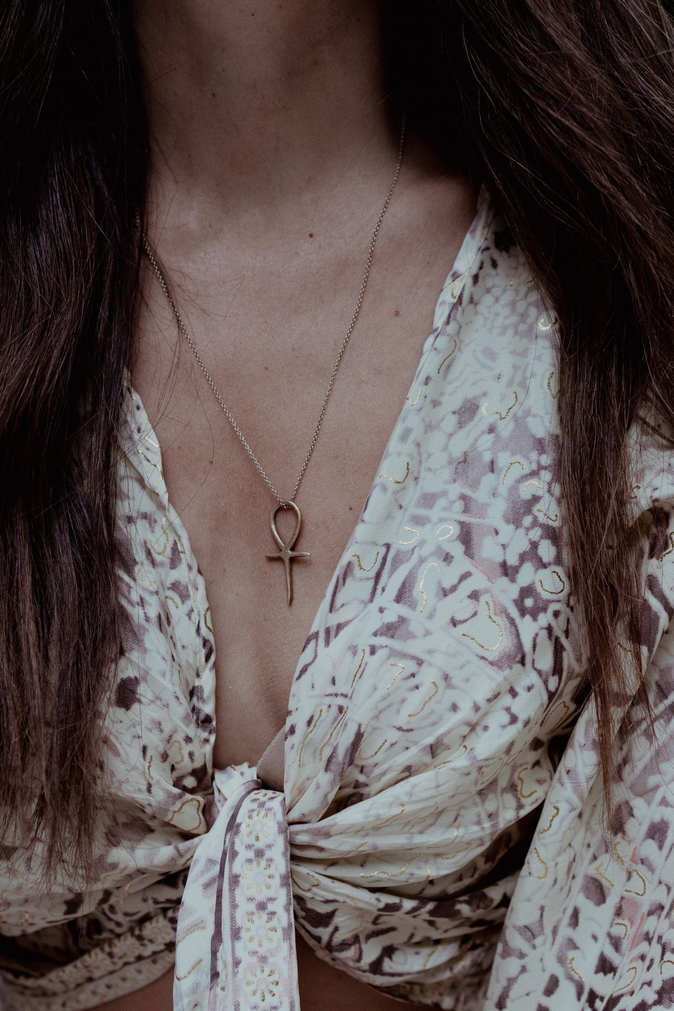Detail shots of a floral print dress with delicate neckline in moody lighting.