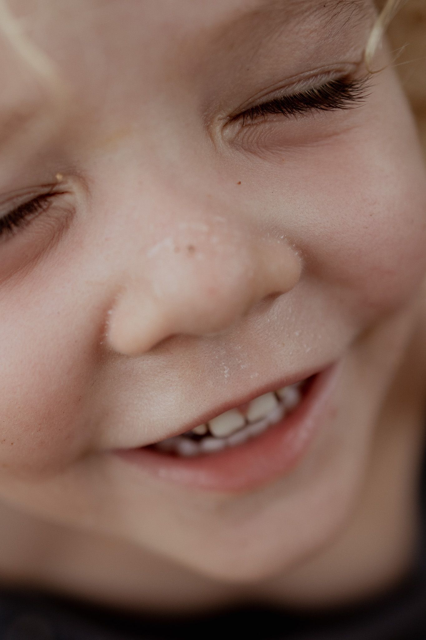 Extreme close-up sequence of a smiling expression showing teeth and dimples.