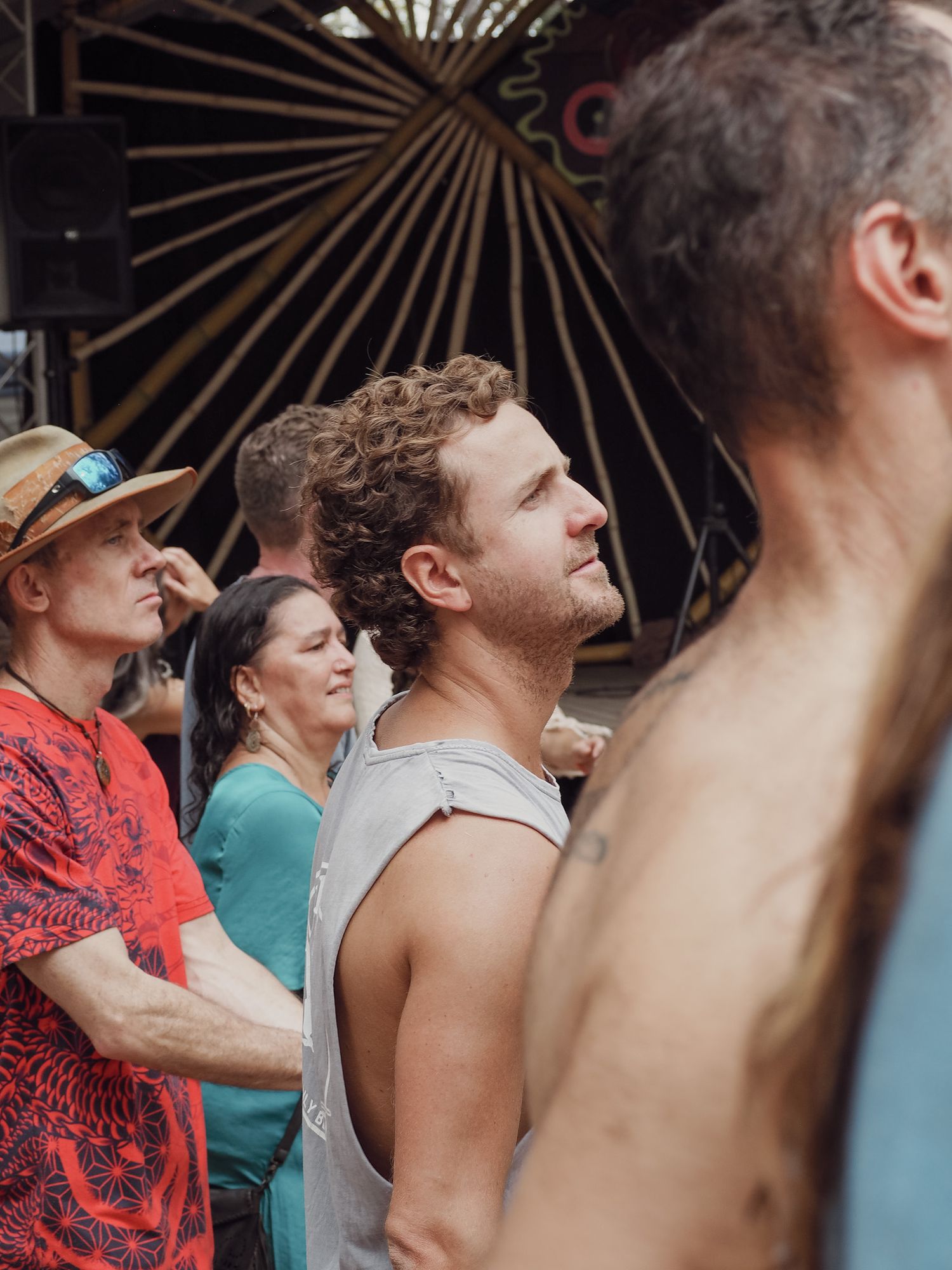 Festival attendees watching performance with sunburst stage decoration in background.