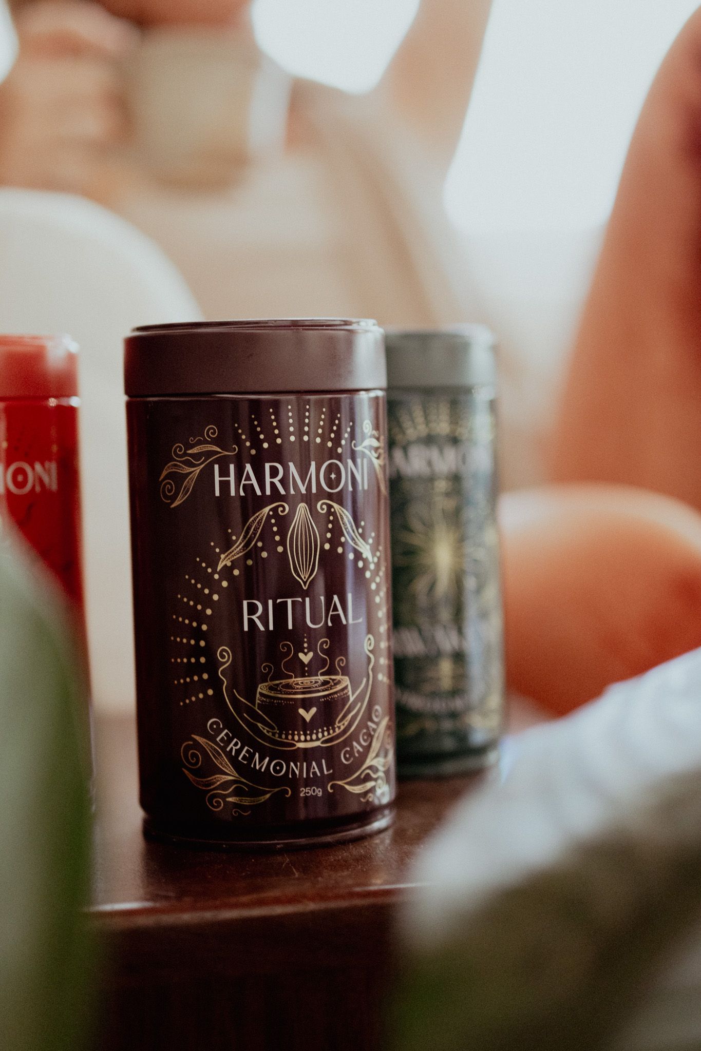 Collection of Harmony ritual candles with elegant gold designs on dark containers.