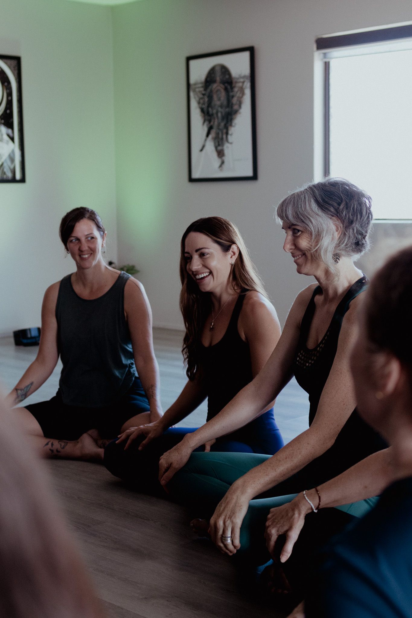 People gathered in a bright room with framed artwork on the walls for a group activity.