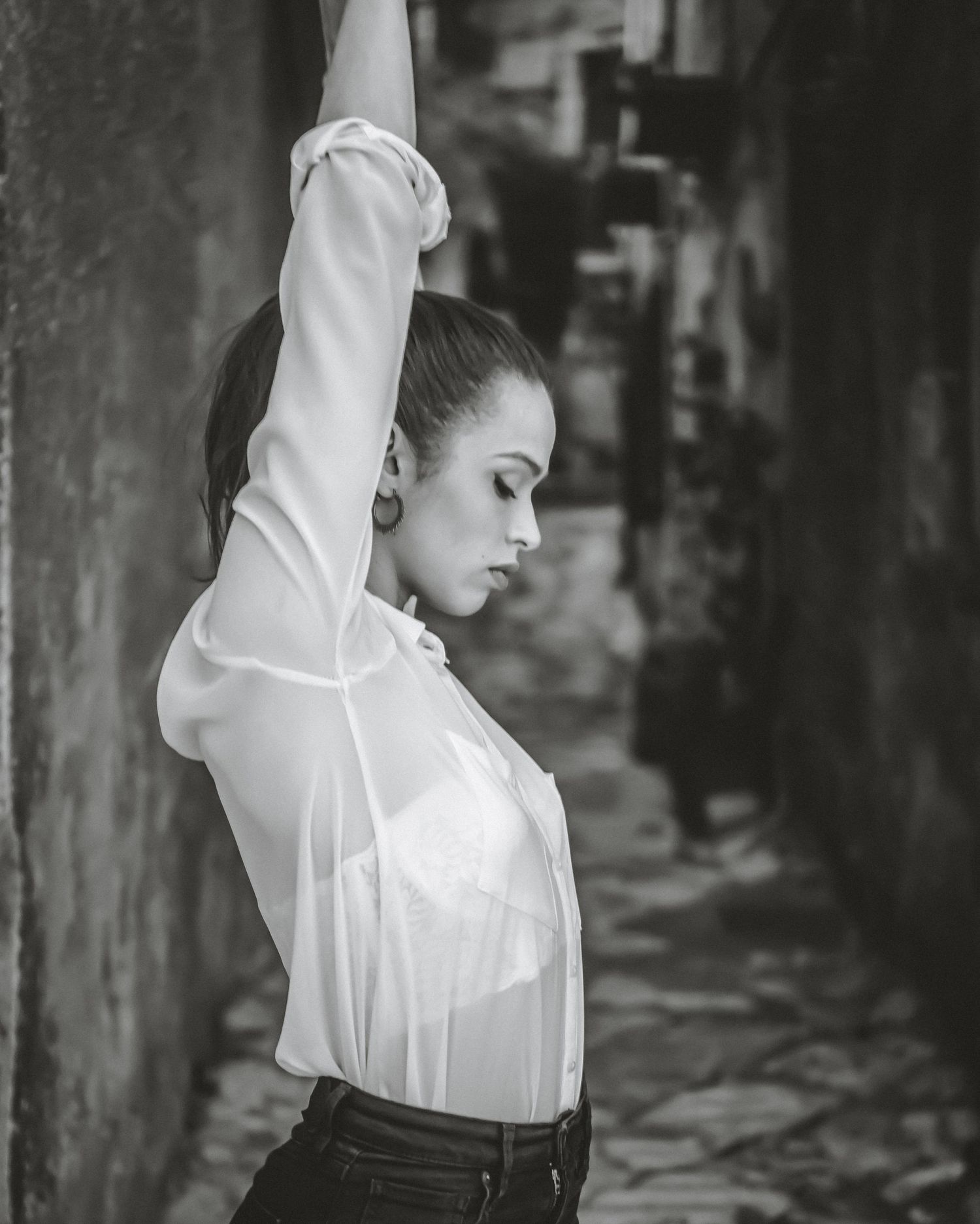 A black and white photo series showing a dancer in a flowing white top performing graceful movements.