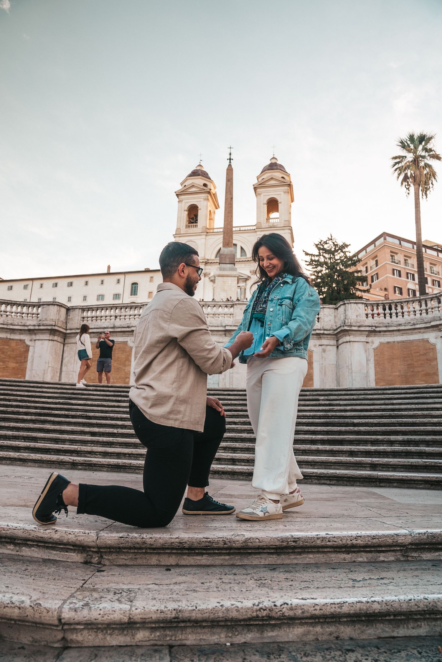 Couple interacting on the historic Spanish Steps in Rome at sunset.