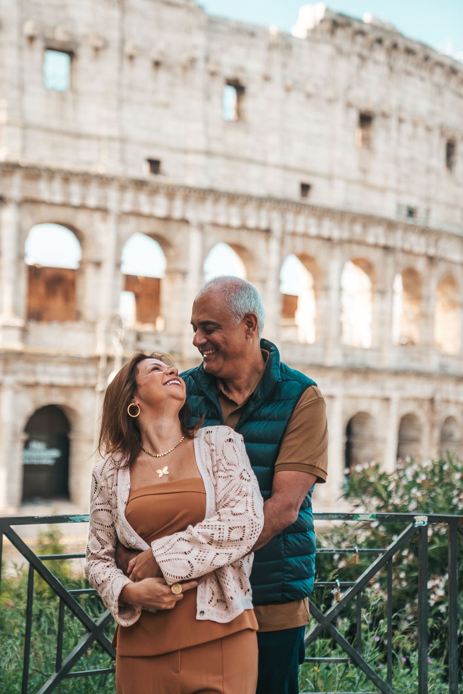 A couple shares joyful moments in front of the historic Roman Colosseum.
