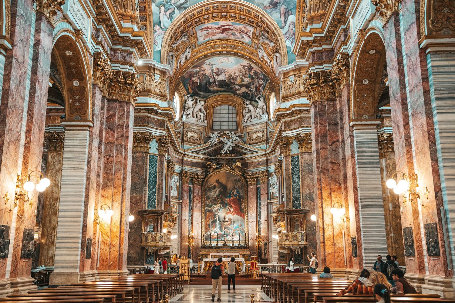 Ornate baroque interior of Stockholm Palace features gilded mirrors, marble columns and crystal chandeliers in a grand hallway.