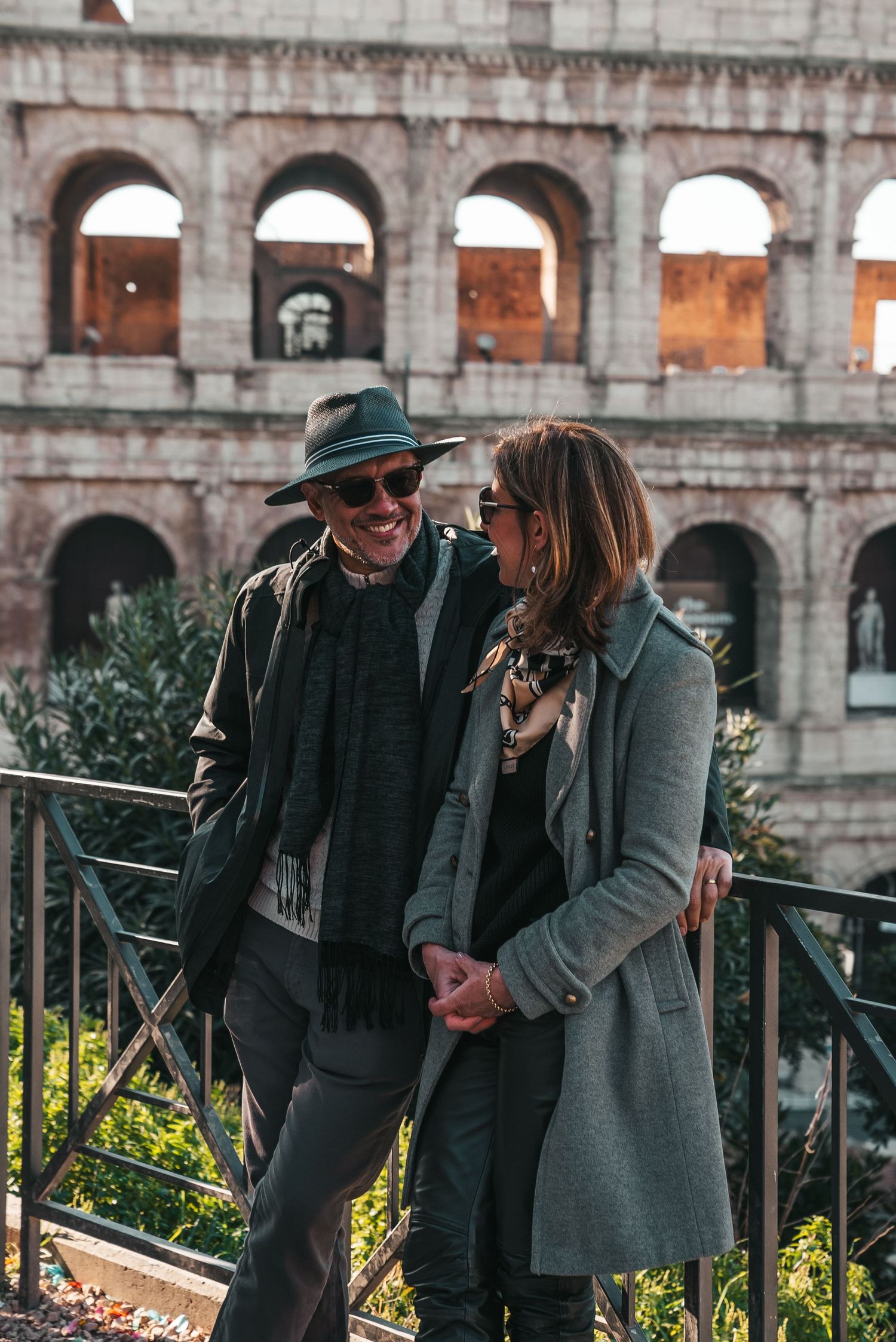 Couple sharing laughs near the Colosseum in Rome during sunset.