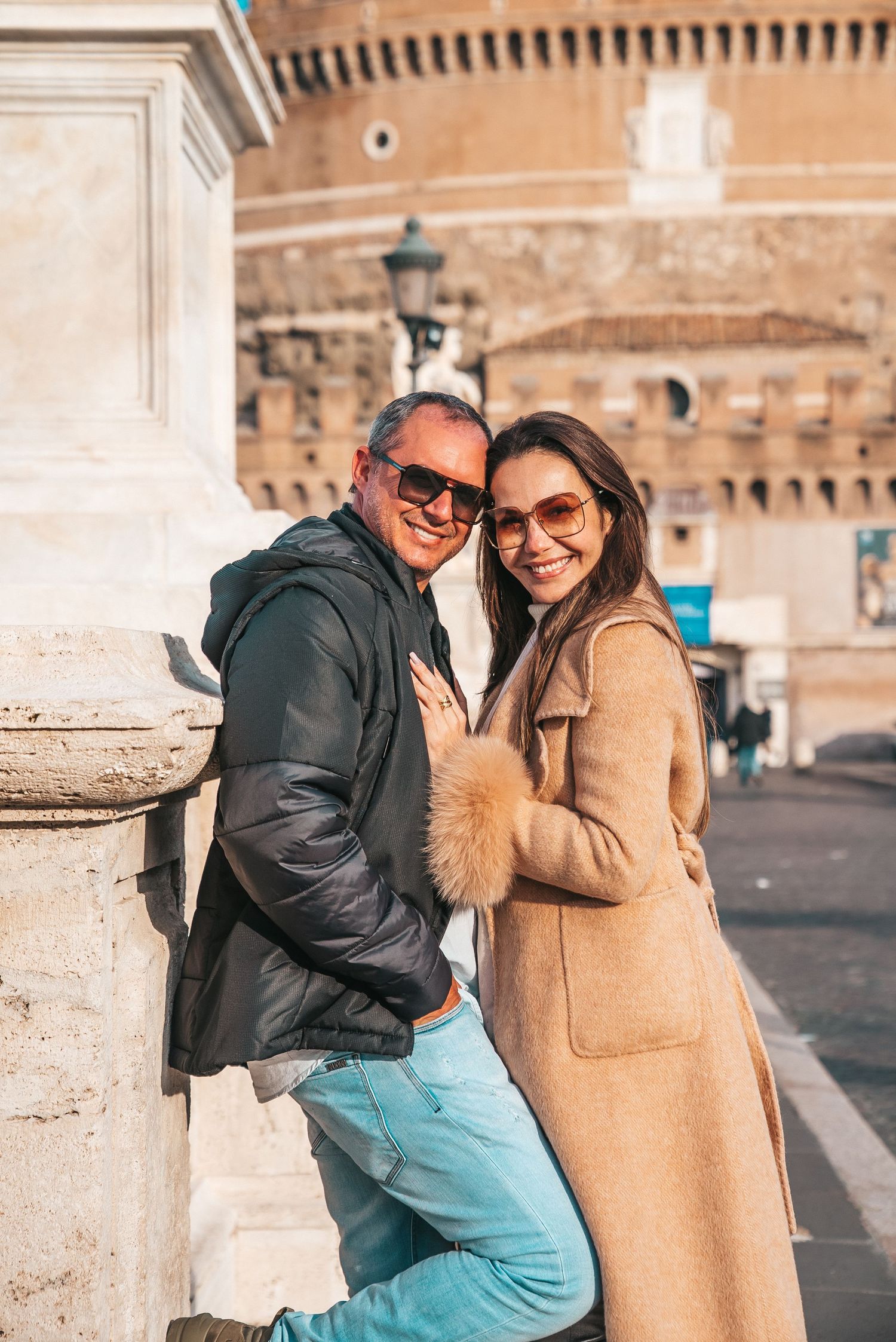 Tourist photos at Castel Sant'Angelo with stone columns and fortress walls in background.