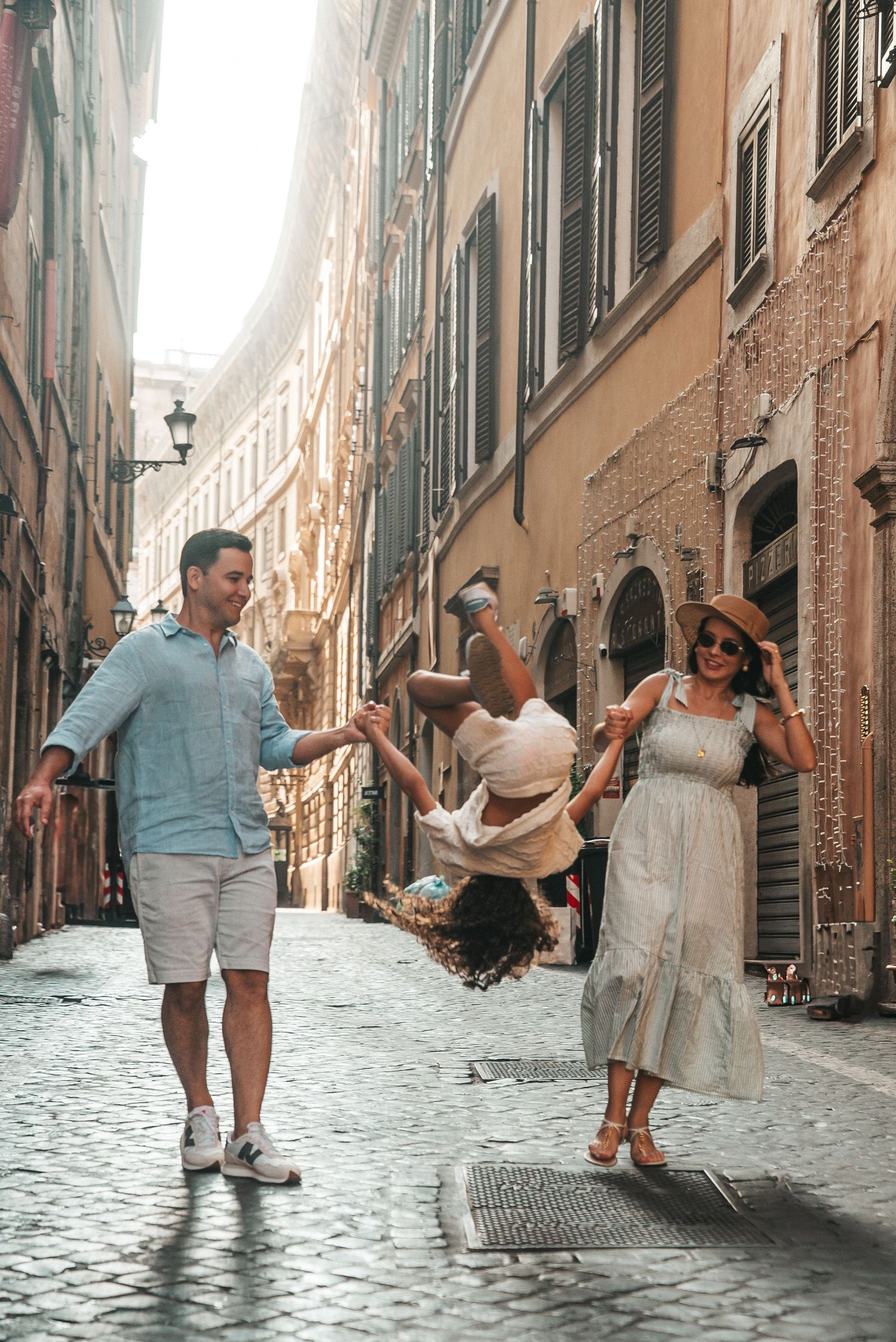 Joyful scene of friends dancing in a charming cobblestone alley in Rome.