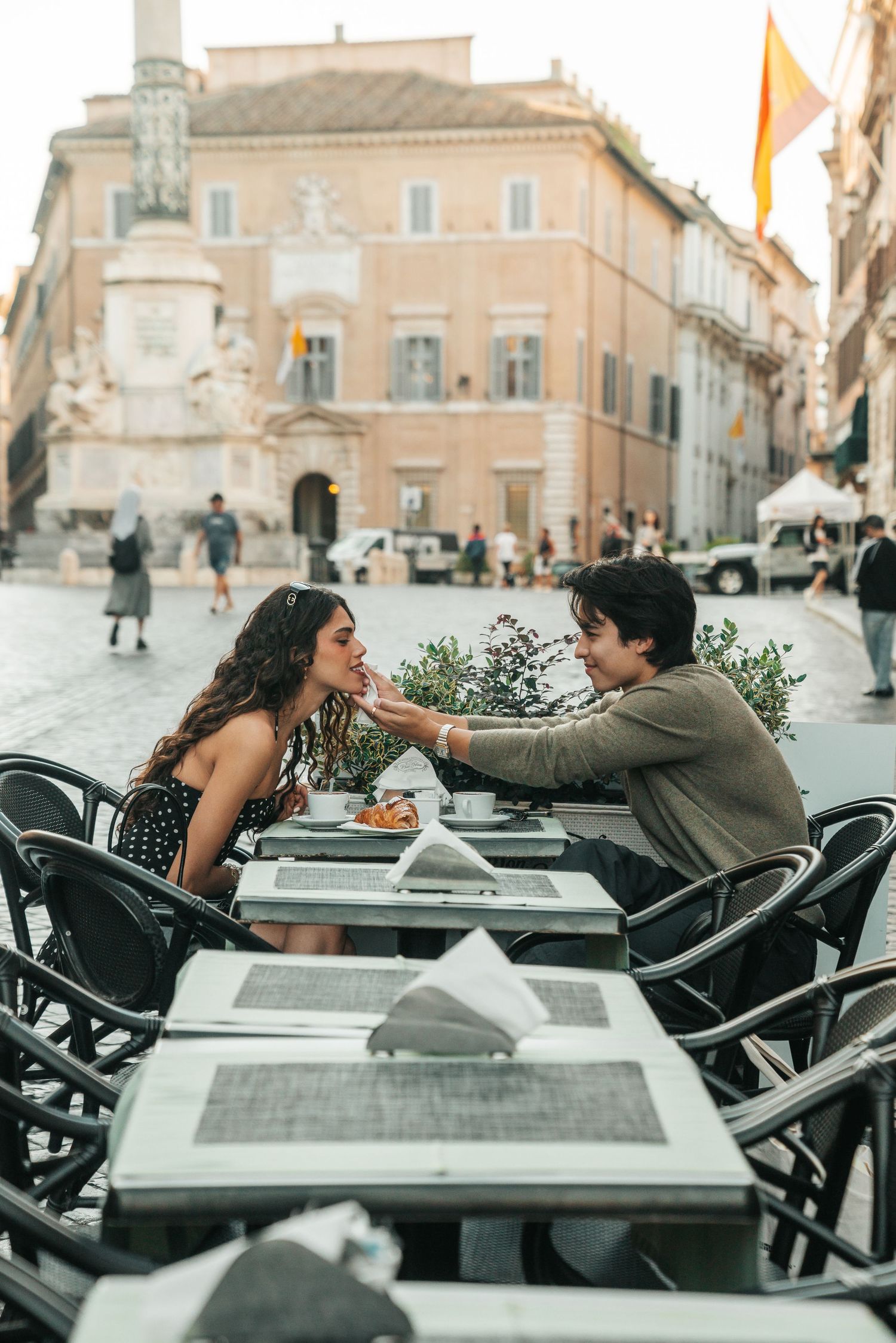 Romantic couple sharing a moment at an outdoor cafe in Italy.