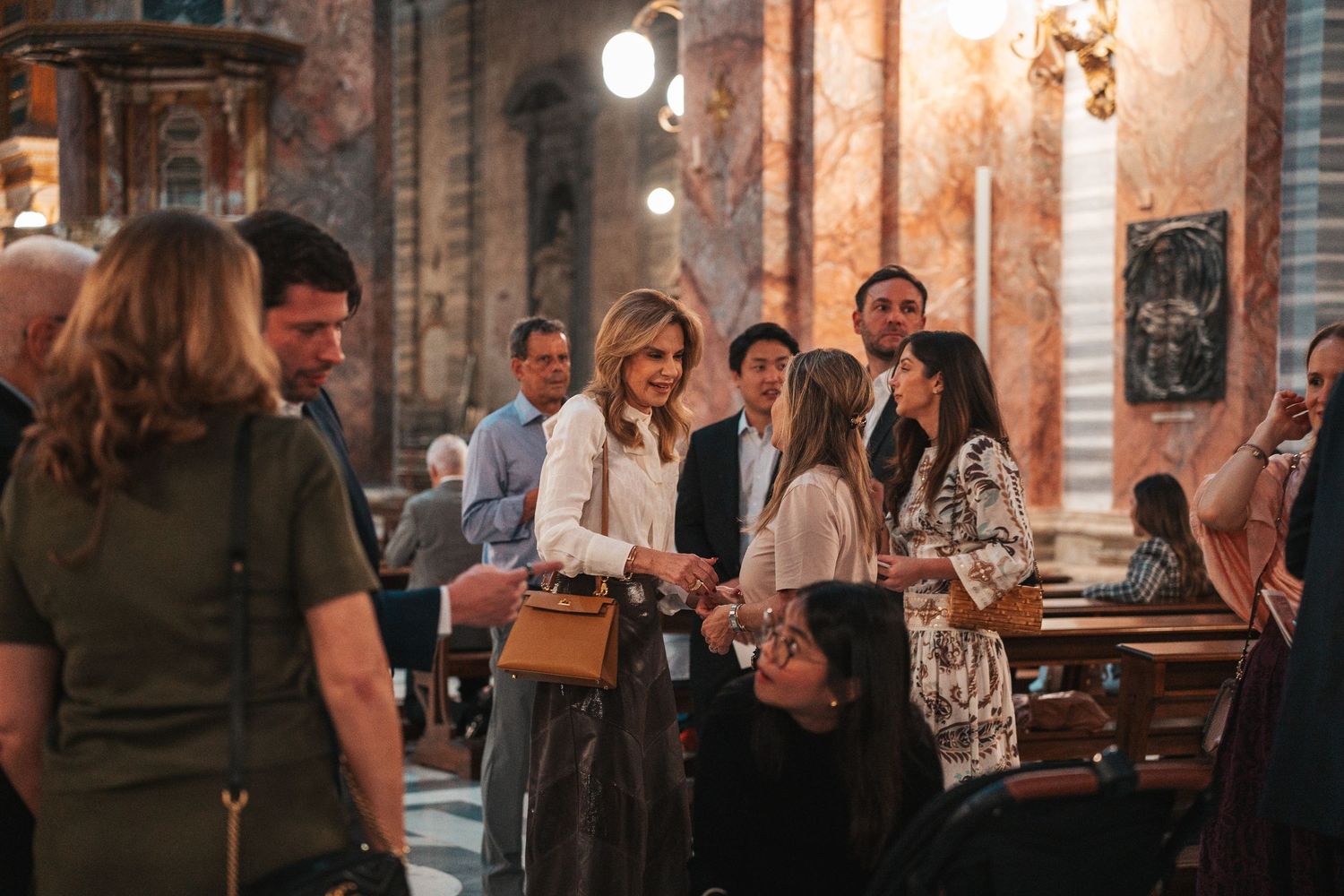 People enjoying wine and conversation at a dimly lit restaurant bar with warm ambient lighting.