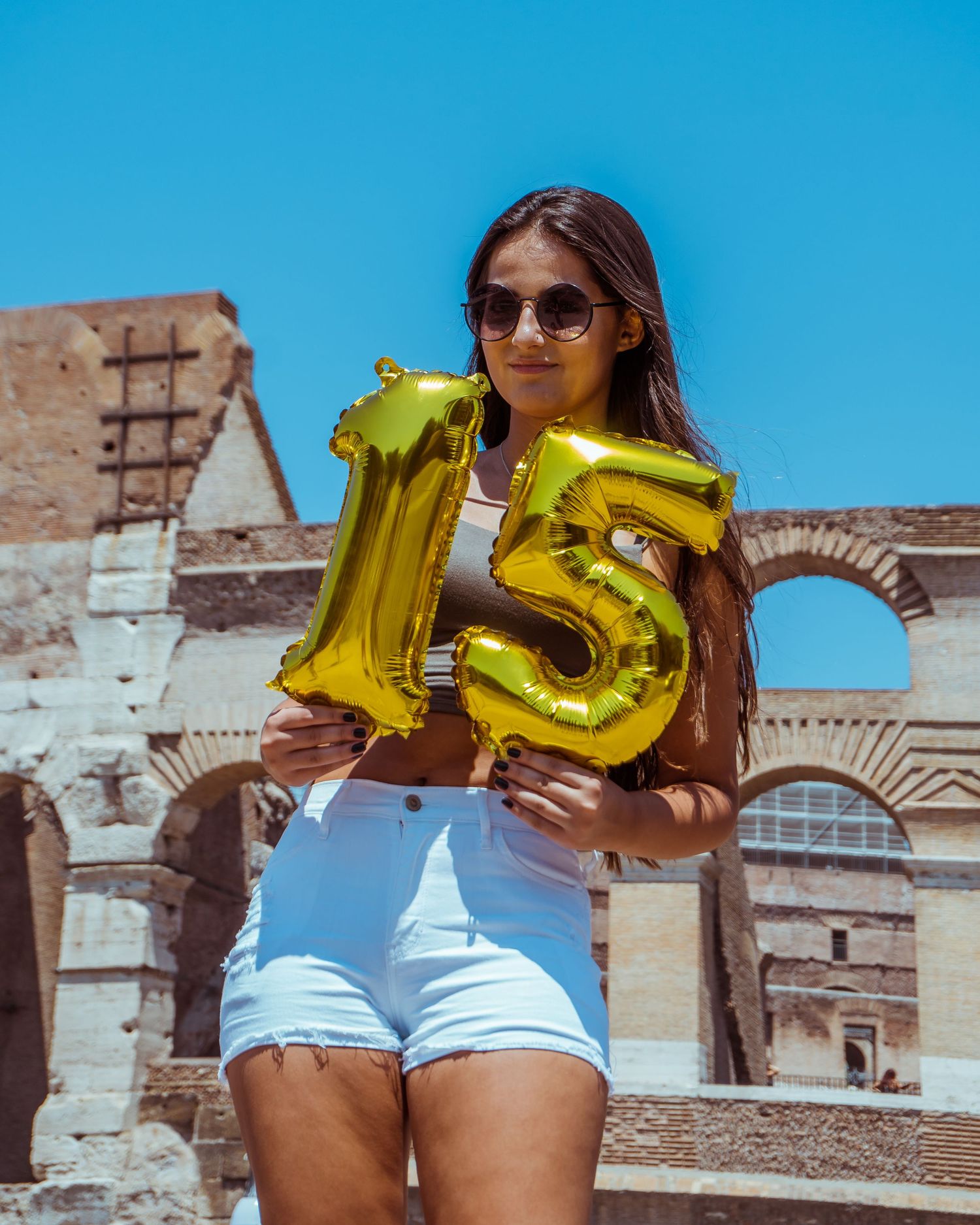 A series of photos showing someone in denim shorts and yellow balloon numbers against an ancient architectural backdrop.